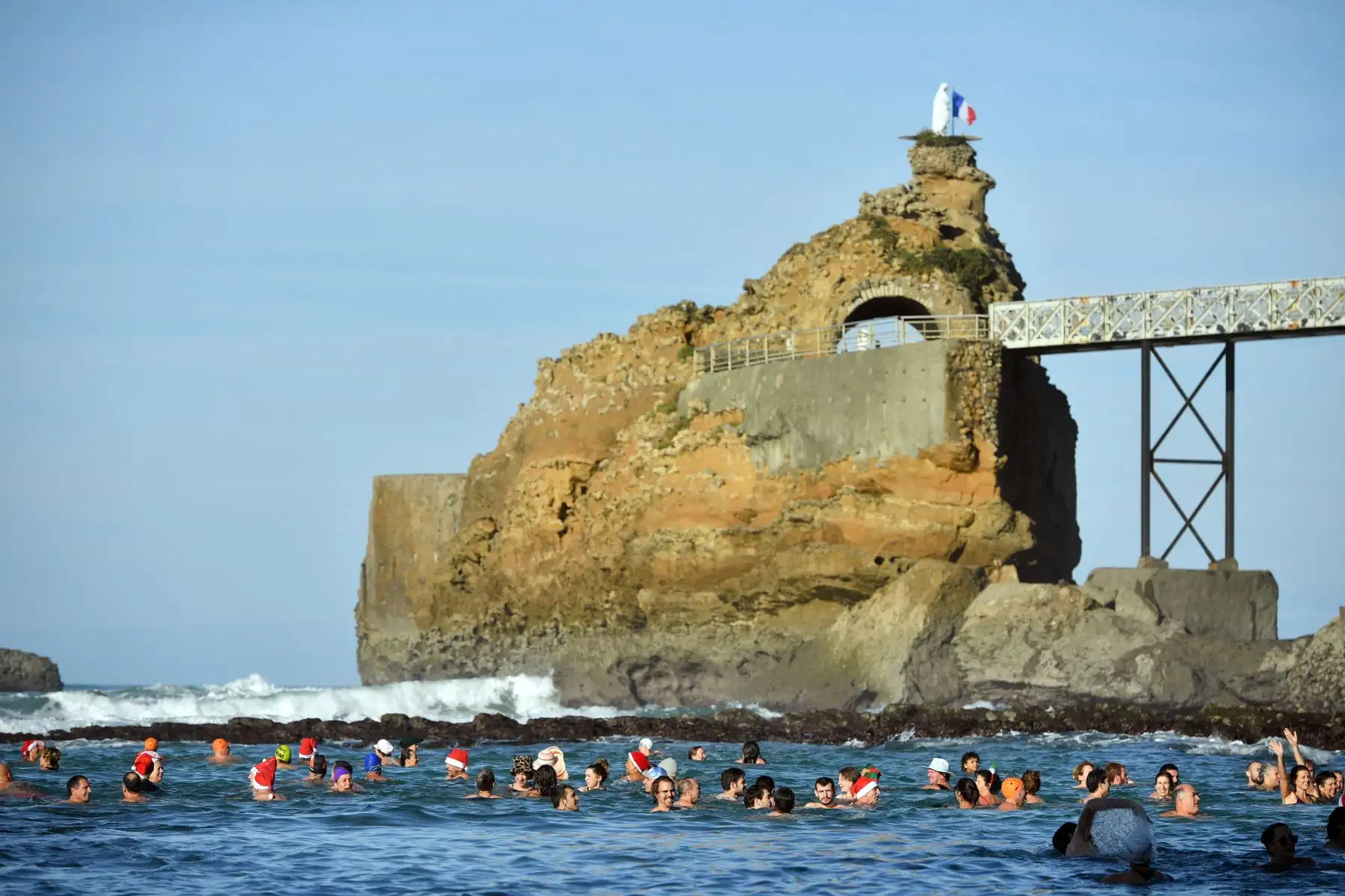 Los bañistas participan en el tradicional baño navideño organizado desde 1929 por la asociación "Les Ours blancs" (osos polares) en la playa de Port Vieux en Biarritz, suroeste de Francia, el 24 de diciembre de 2022. Foto: AFP
