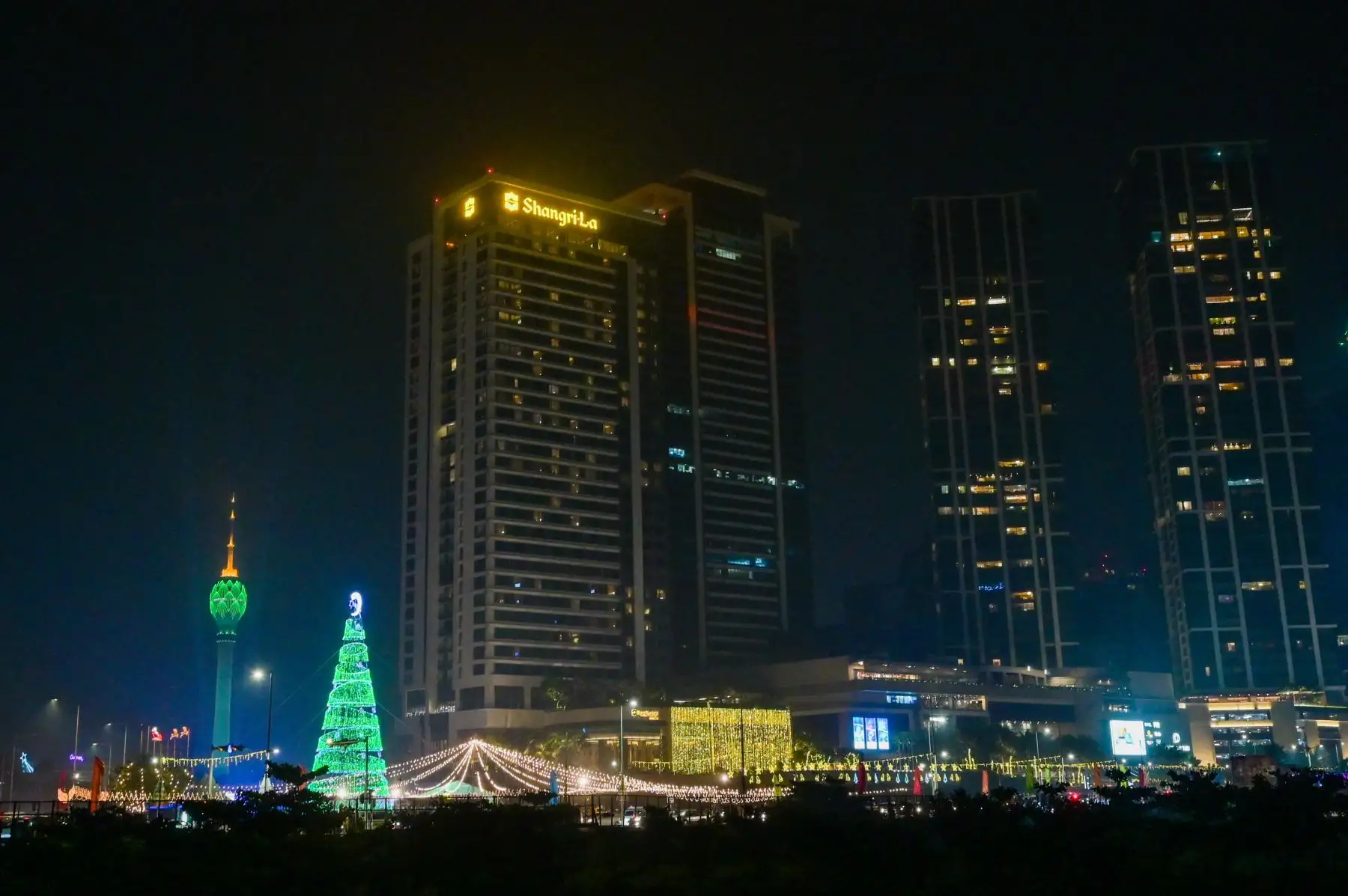 La gente camina por una calle iluminada en la víspera de Navidad, en Colombo. Foto: AFP