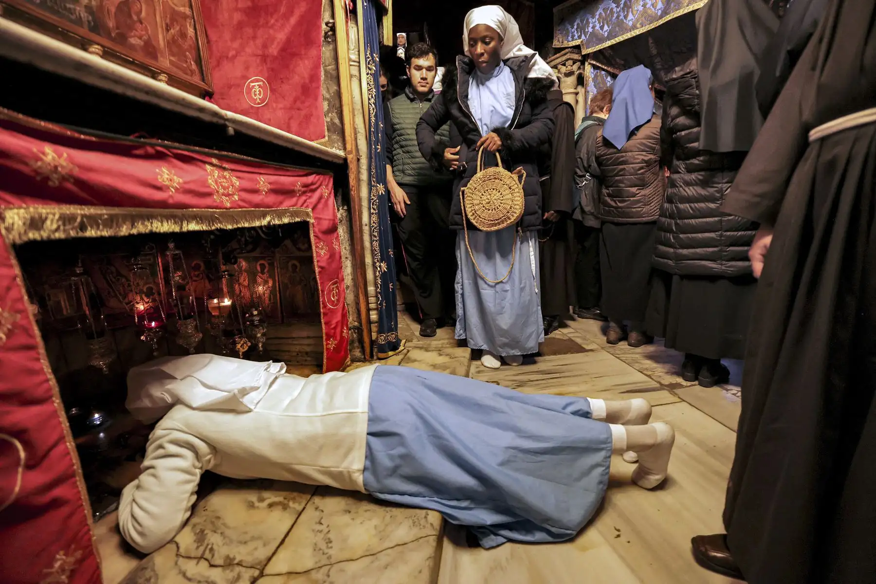 Un peregrino yace boca abajo en oración mientras llega a la gruta, que se cree que es el lugar del nacimiento de Jesús, en la cripta de la Iglesia de la Natividad en la ciudad bíblica de Belén en Cisjordania ocupada el día de Navidad. Foto: AFP
