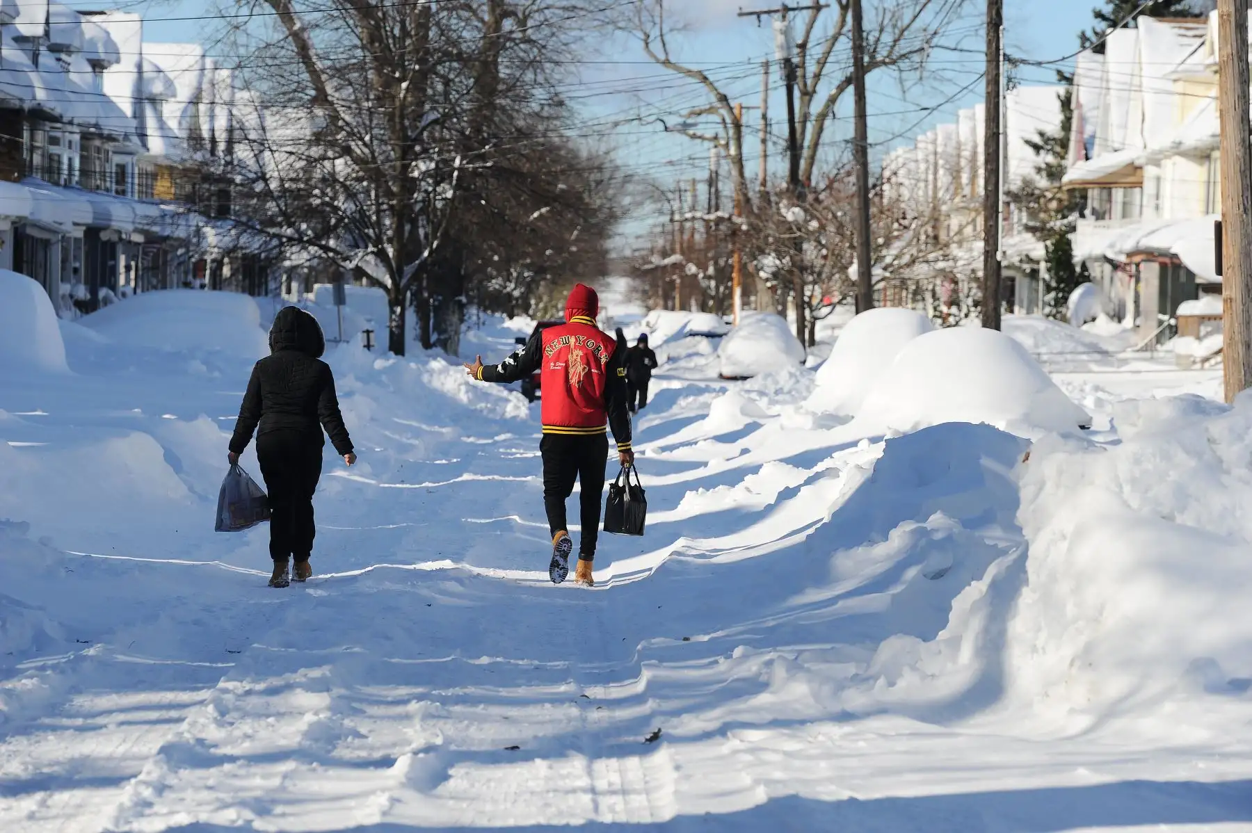 Los peatones recorren calles cubiertas de nieve después de una intensa tormenta de nieve con efecto lago que afectó a Nueva York, la tormenta de nieve resultó en una acumulación de hasta seis pies y se le ha atribuido al menos tres muertes.  Foto AFP