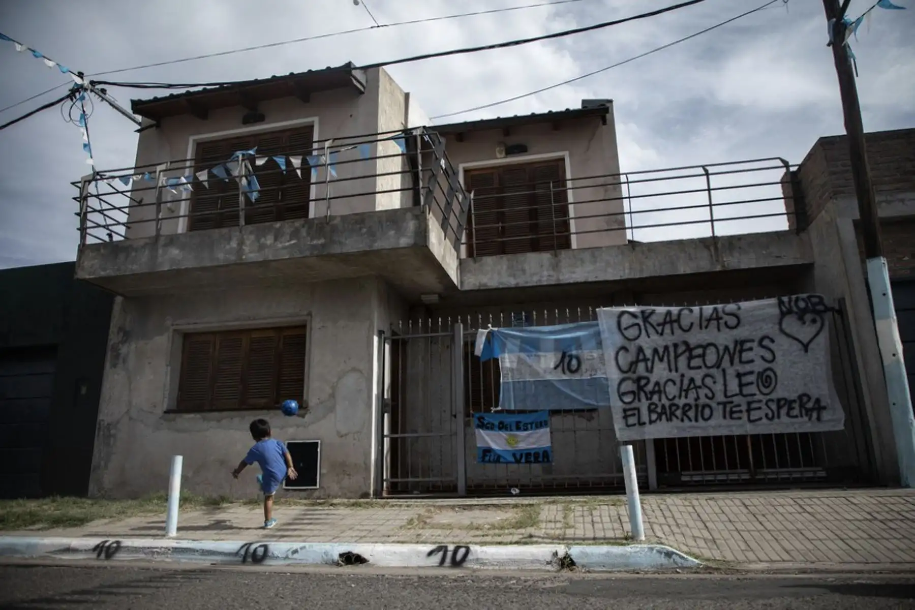 Nahitan Almarás, de 2 años de edad, jugando a la pelota frente a la casa natal de Lionel Messi, en el barrio La Bajada, en la ciudad de Rosario, Argentina.
Foto: Xinhua