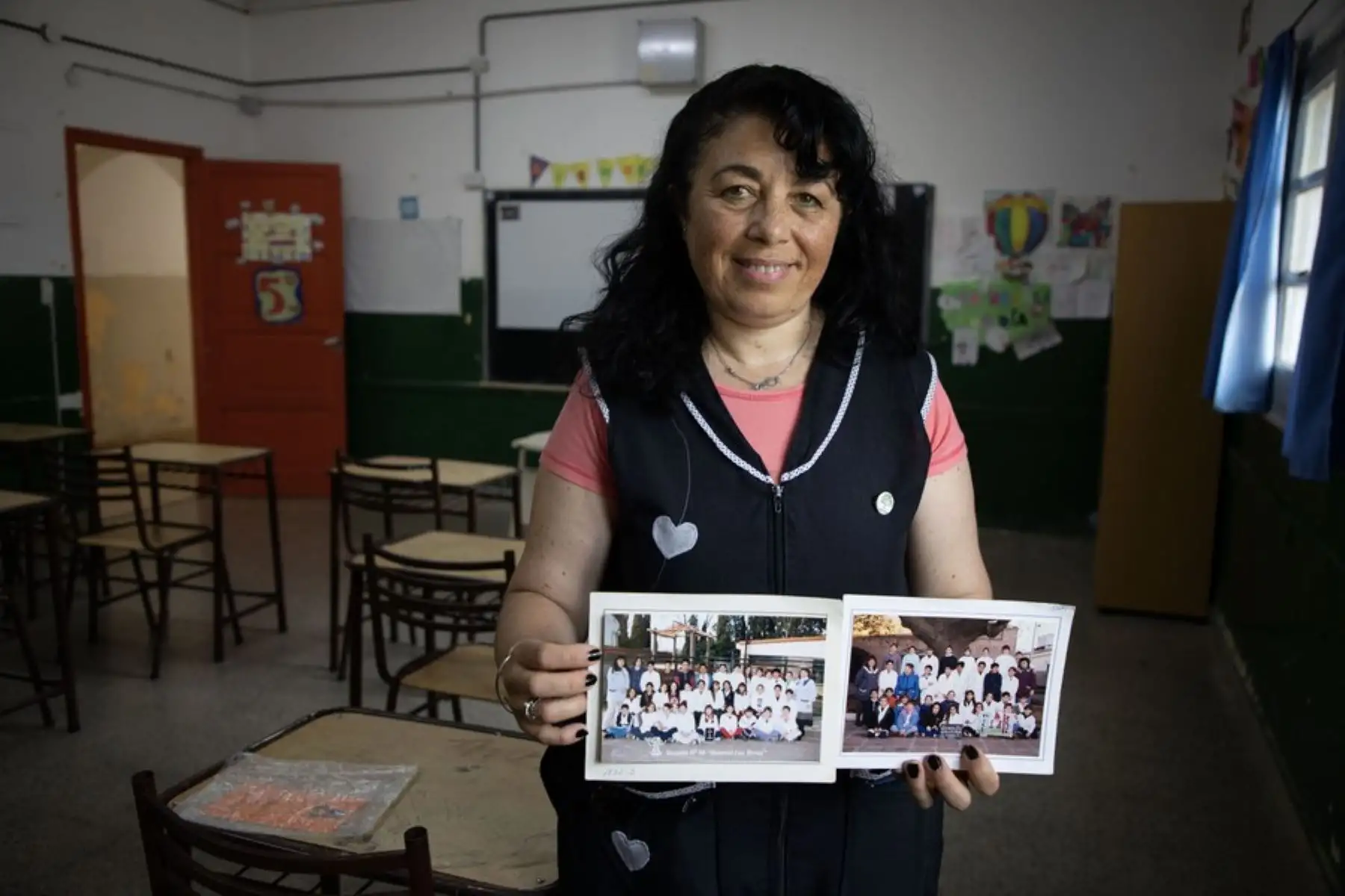 Andrea Sosa, maestra de quinto y sexto grado de Lionel Messi, posando con fotografías de los cursos que asistió el jugador argentino en la Escuela N° 66 General Las Heras, en la ciudad de Rosario, Argentina. 
Foto: Xinhua