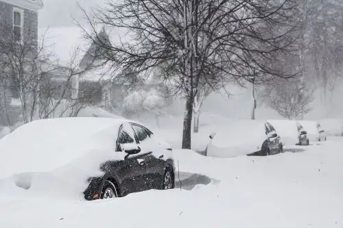 Carros en una larga hilera permanecen cubiertos por la nieve en Búfalo, Estados Unidos, durante la tormenta gélida Elliot. Foto: EFE.