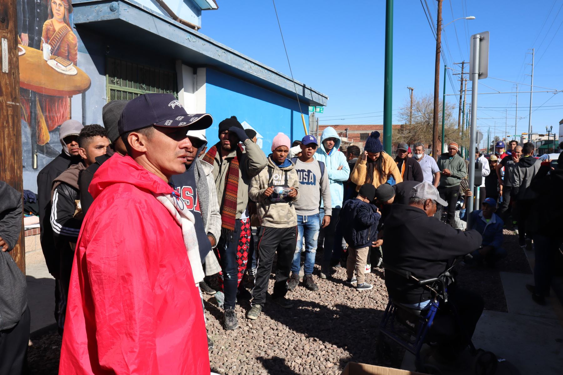 Inmigrantes esperan en una fila para recibir ayuda de alimentos y ropa cerca de un albergue en El Paso (EEUU). Foto: EFE.