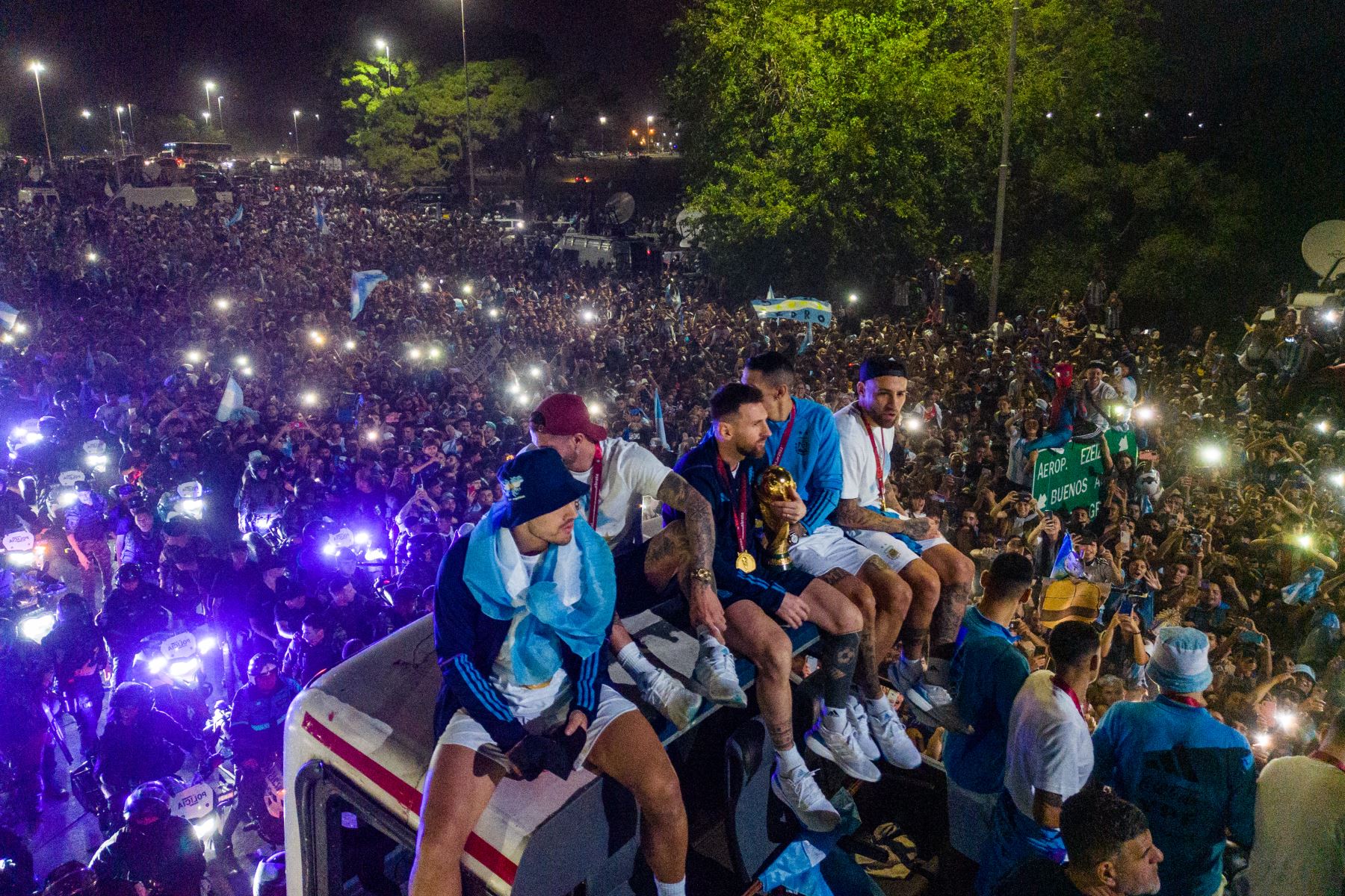 El capitán y delantero argentino Lionel Messi (C) sostiene el Trofeo de la Copa Mundial de la FIFA a bordo de un autobús mientras celebra junto a sus compañeros y seguidores después de ganar el torneo de la Copa Mundial Qatar 2022 en Ezeiza, provincia de Buenos Aires, Argentina el 20 de diciembre de 2022.


Foto: AFP