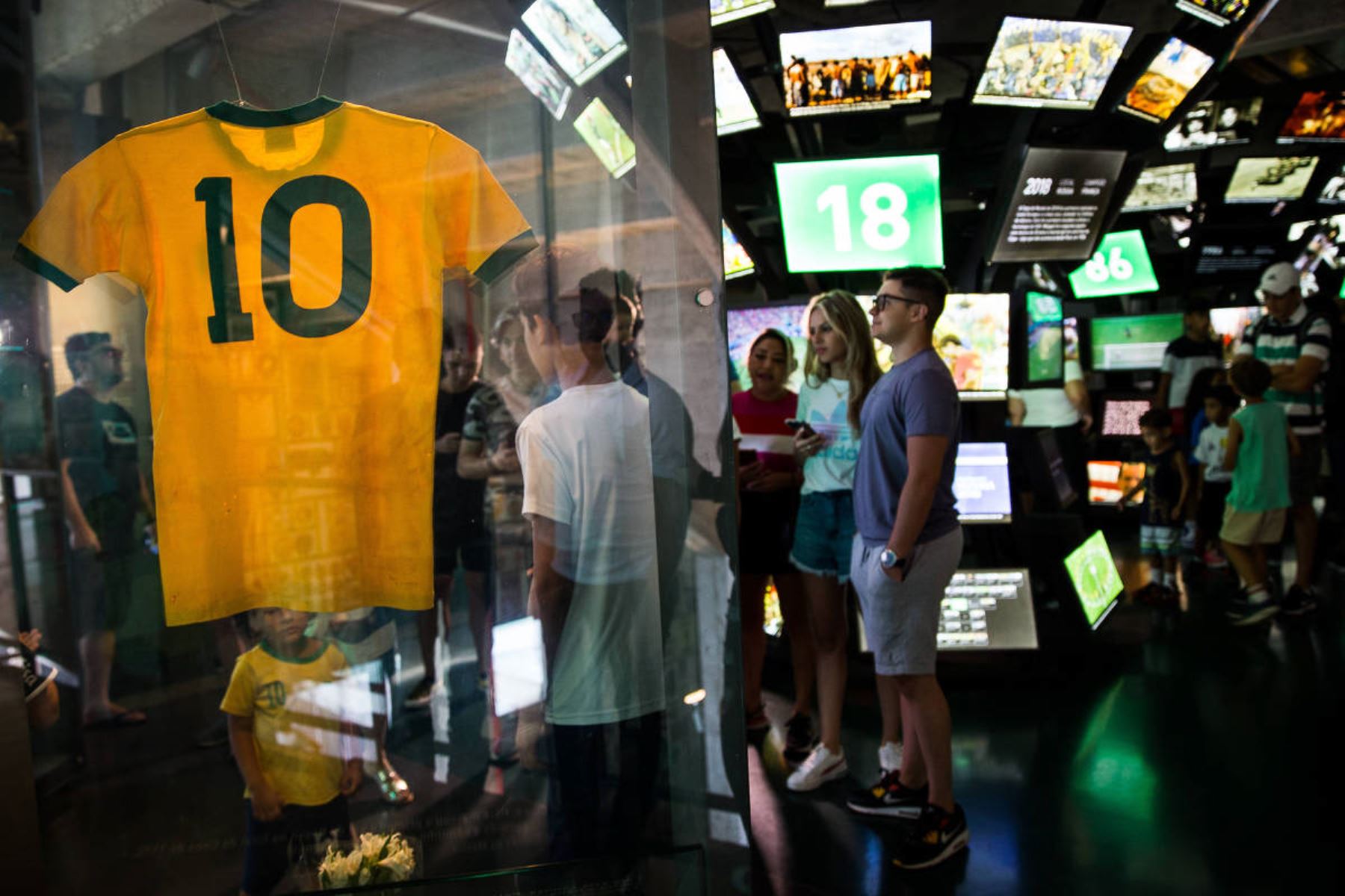 Los visitantes del Museo del Fútbol de Sao Paulo observan y fotografían la legendaria camiseta con el número 10 de Pelé, que usó en la Copa del Mundo de 1970. Foto: Zanone Fraissat/Folhapress