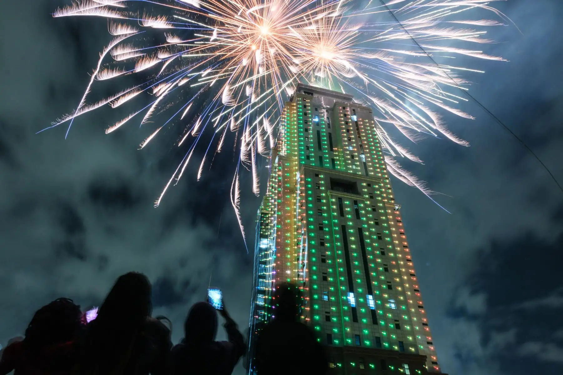 La gente mira el lanzamiento de fuegos artificiales desde el edificio de Old Mutual Tower para celebrar el año nuevo en Nairobi el 1 de enero de 2023. Foto: AFP