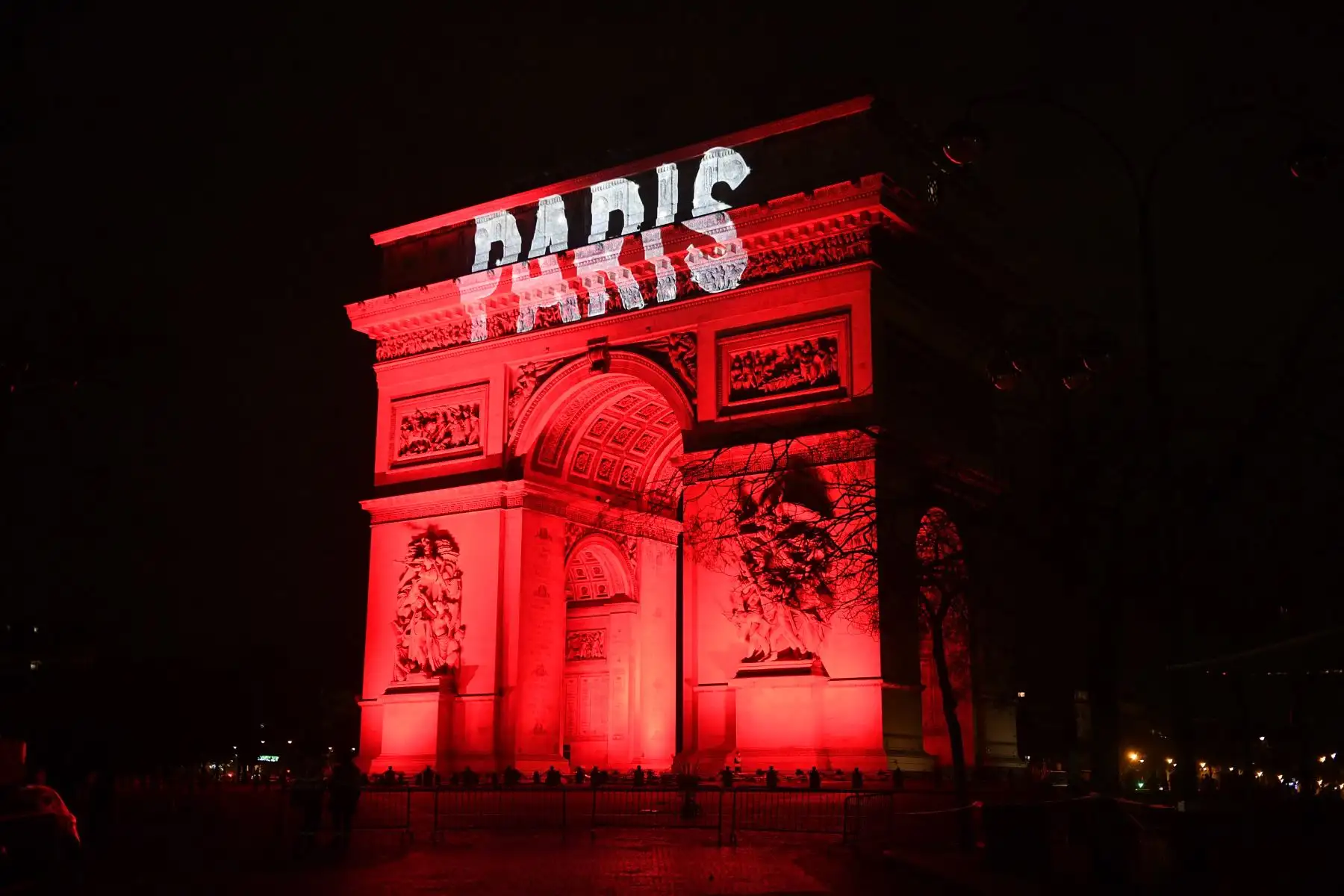 Esta fotografía tomada el 31 de diciembre de 2022 muestra el edificio del Arco del Triunfo con iluminación roja y una proyección de la palabra "París" como parte de las celebraciones de Nochevieja en París. Foto: AFP