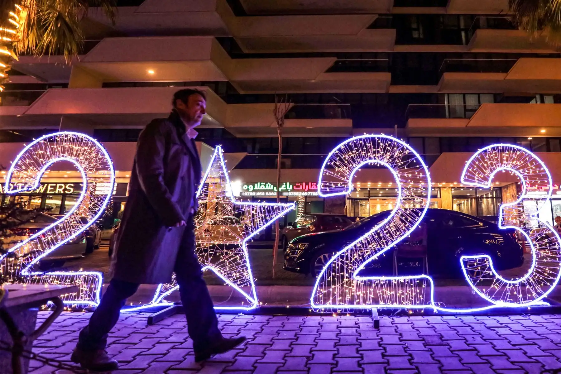 Un hombre camina cerca de una instalación iluminada que representa el número del año "2023" colocada como parte de las decoraciones de año nuevo en Arbil, la capital de la región autónoma del Kurdistán iraquí, el 29 de diciembre de 2022. Foto: AFP