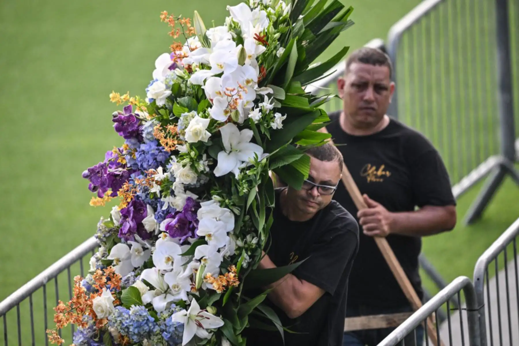 Un hombre lleva una corona de flores dentro del estadio Vila Belmiro antes del inicio del velorio de la leyenda del fútbol brasileño Pelé en Santos, en Sao Paulo. Foto: AFP