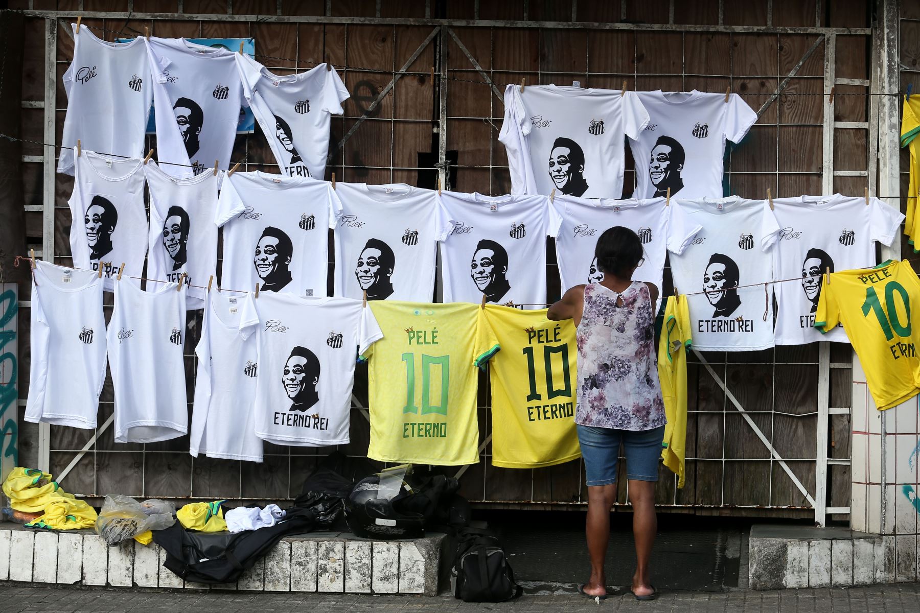 Una mujer vende camisetas con la imagen de Pelé, en las afueras del estadio de Santos donde se desarrolla el velatorio del 