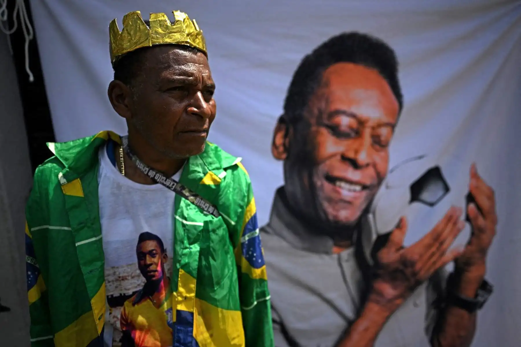 Un fanático de la estrella del fútbol brasileño, Pelé, se reúne en la calle mientras un camión de bomberos transporta el ataúd de Pelé al Cementerio Conmemorativo de Santos en Santos, estado de Sao Paulo, Brasil. Foto: AFP