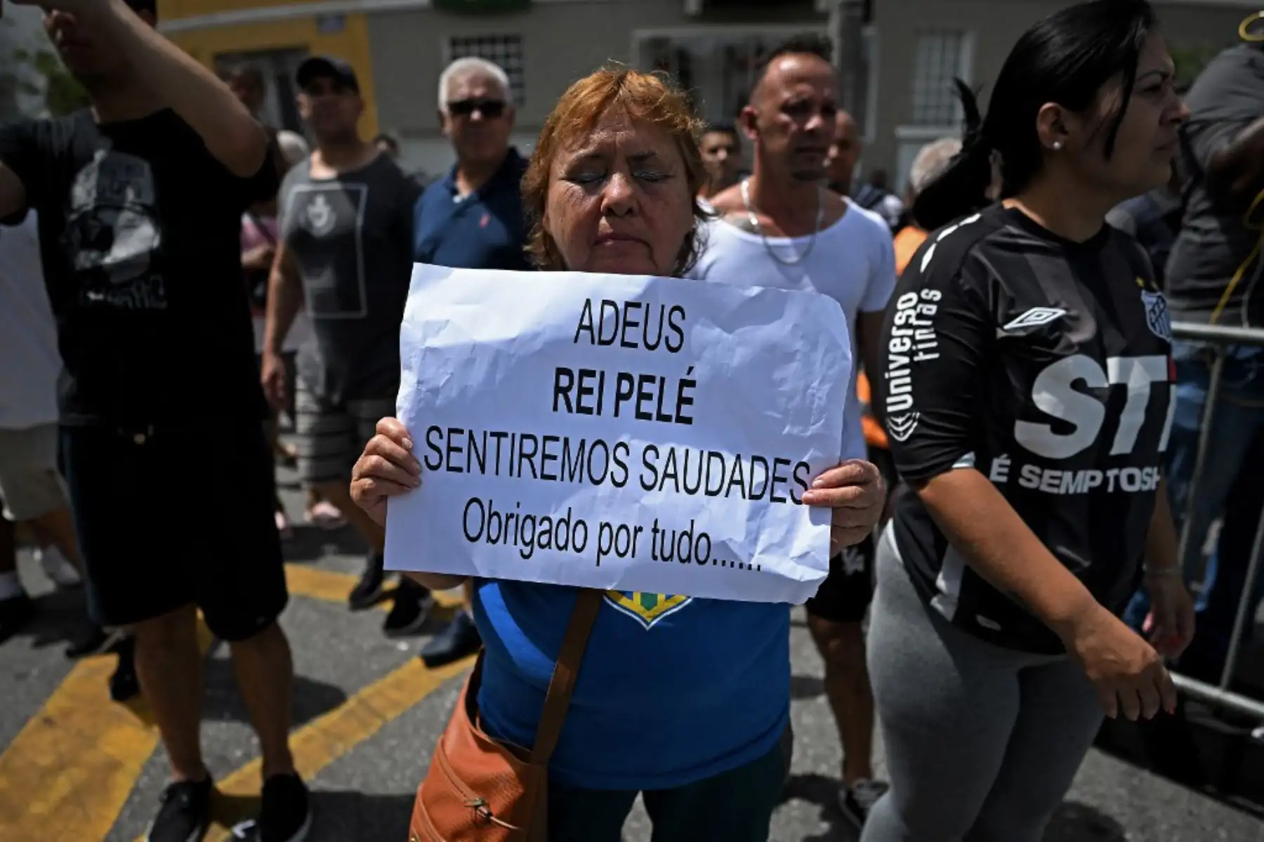 Los fanáticos de la difunta estrella del fútbol brasileño Pelé se reúnen en la calle mientras un camión de bomberos transporta el ataúd de Pelé al Cementerio Conmemorativo de Santos en Santos, estado de Sao Paulo, Brasil. Foto: AFP