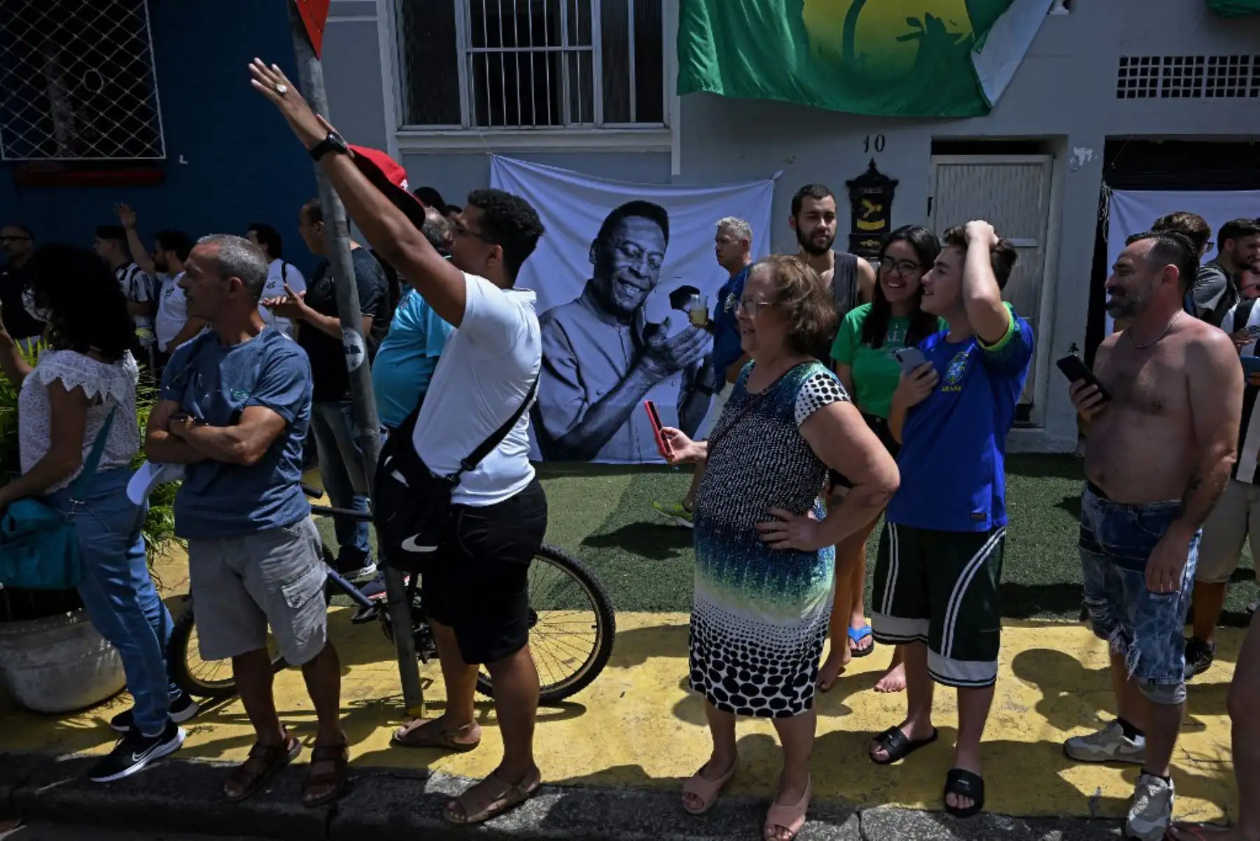 Los fanáticos de la difunta estrella del fútbol brasileño Pelé se reúnen en la calle mientras un camión de bomberos transporta el ataúd de Pelé al Cementerio Conmemorativo de Santos en Santos, estado de Sao Paulo, Brasil. Foto: AFP