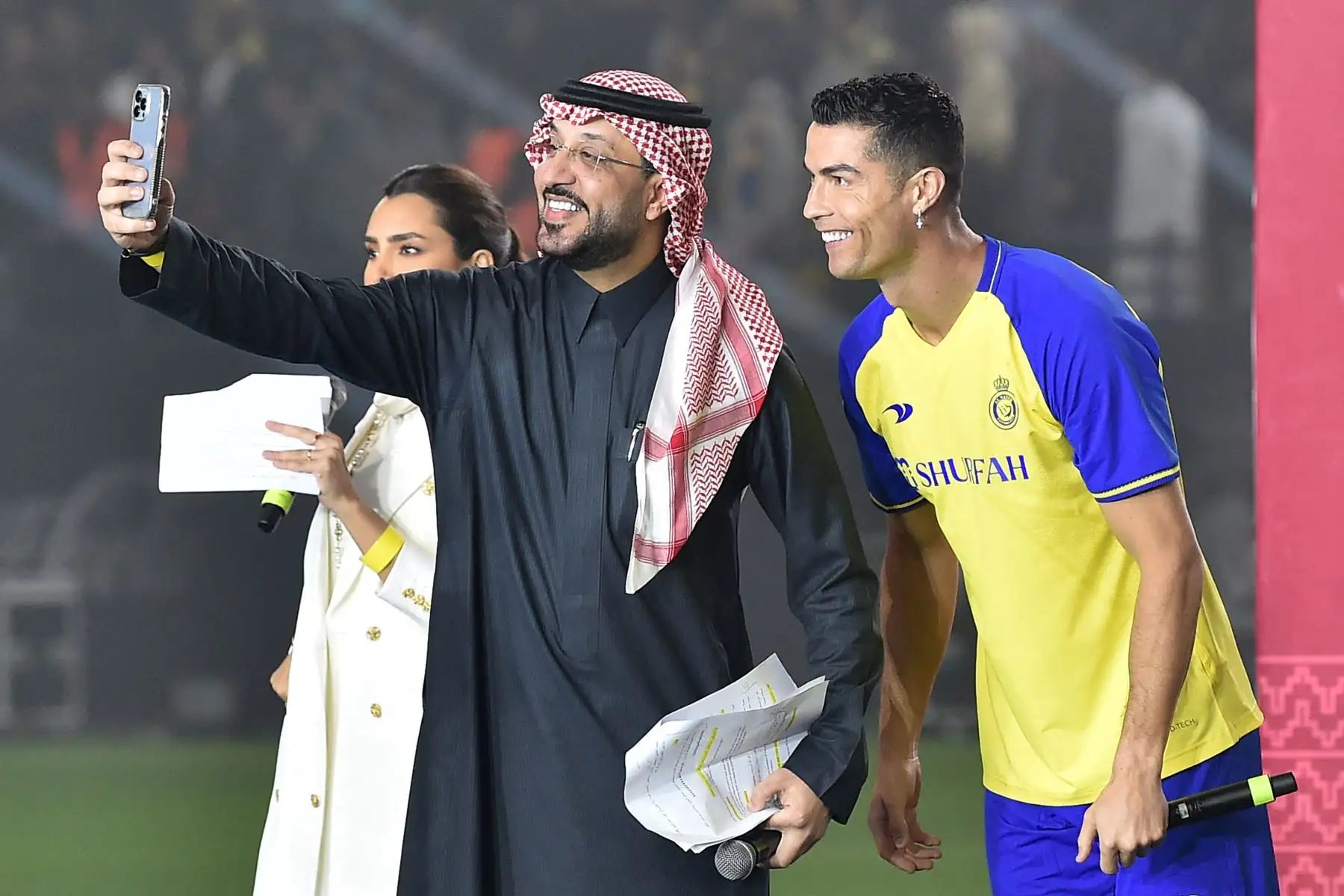 El nuevo delantero portugués de Al-Nassr, Cristiano Ronaldo (derecha), posa para una selfie con los presentadores durante su presentación en el estadio Mrsool Park en la capital saudí, Riad, el 3 de enero de 2023. Foto: AFP