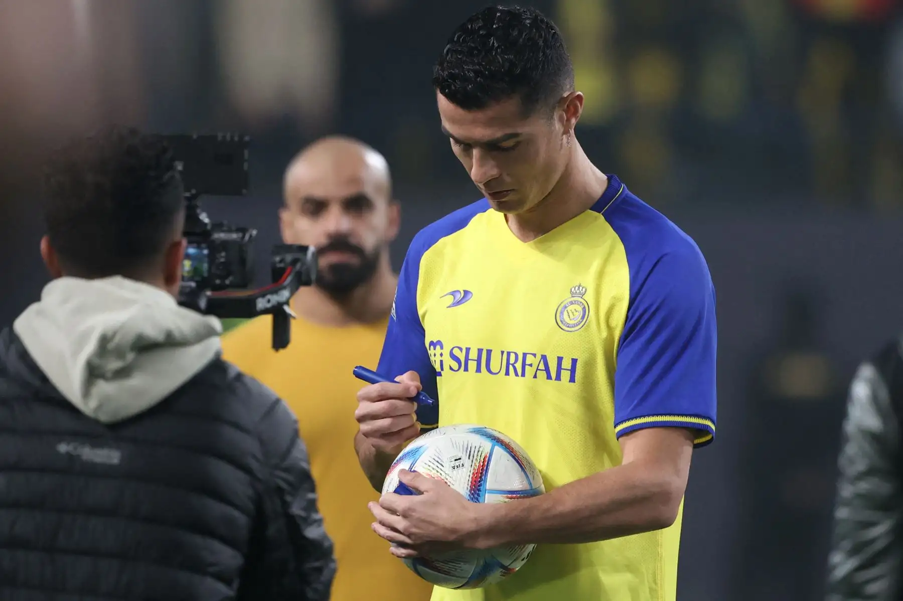 El nuevo delantero portugués de Al-Nassr, Cristiano Ronaldo, firma un balón para los fanáticos durante su inauguración en el estadio Mrsool Park en la capital saudí, Riad, el 3 de enero de 2023. Foto: AFP