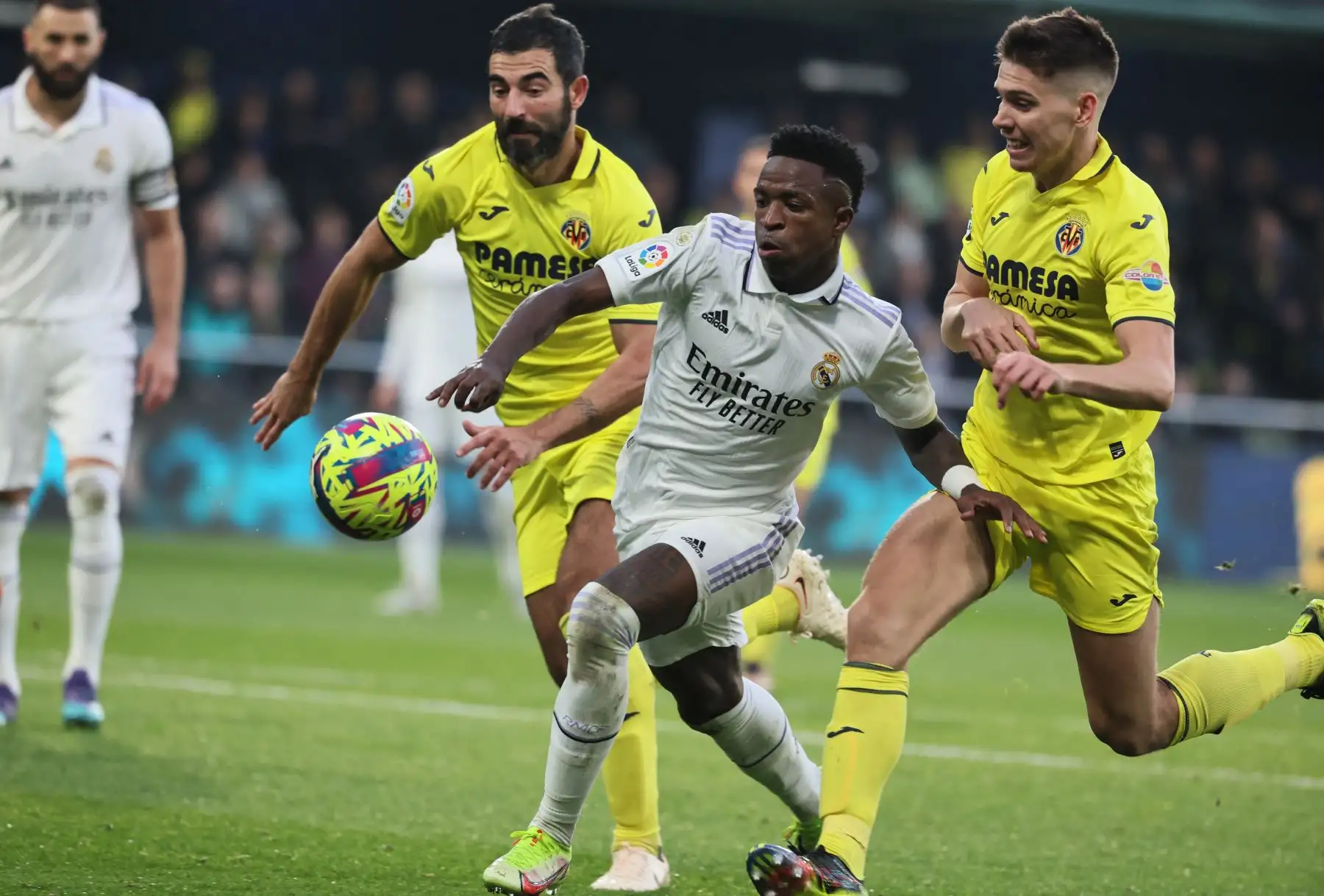 El delantero brasileño del Real Madrid, Vinicius Junior, compite con el defensor español del Villarreal, Raúl Albiol, y el defensor argentino del Villarreal, Juan Foyth, durante el partido de fútbol de la Liga española entre el Villarreal CF y el Real Madrid. Foto: AFP