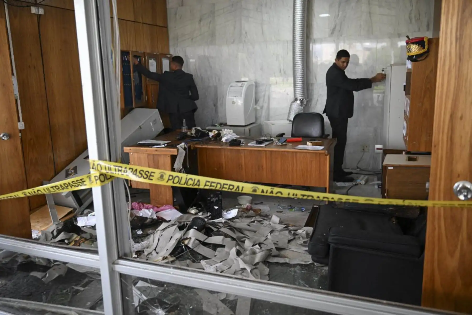 Miembros de seguridad del Palacio Presidencial de Planalto inspeccionan oficinas destruidas por partidarios del expresidente brasileño Jair Bolsonaro. Foto: AFP