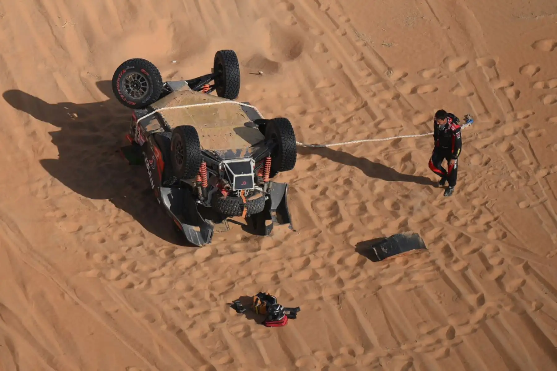 El sudafricano Brian Baragwanath aparece junto a su automóvil después de un accidente durante la Etapa 13 del Dakar 2023 entre Saybah y al-Hofuf, en Arabia Saudita. Foto: AFP