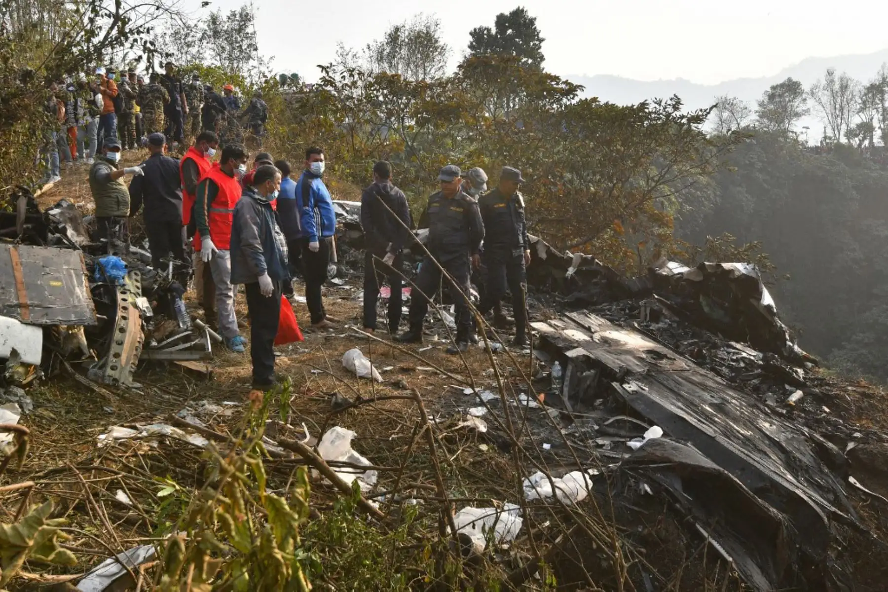 Rescatistas se reúnen en el lugar de un accidente aéreo en Pokhara. Al menos 67 personas fueron confirmadas muertas el 15 de enero cuando un avión con 72 a bordo se estrelló en Nepal. Foto: AFP