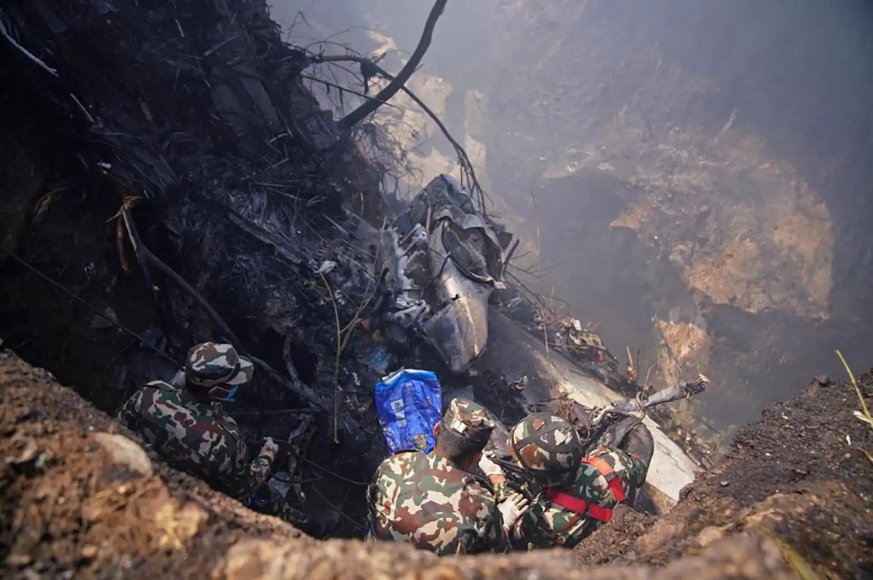 Rescatistas se reúnen en el lugar de un accidente aéreo en Pokhara. Al menos 67 personas fueron confirmadas muertas el 15 de enero cuando un avión con 72 a bordo se estrelló en Nepal. Foto: AFP