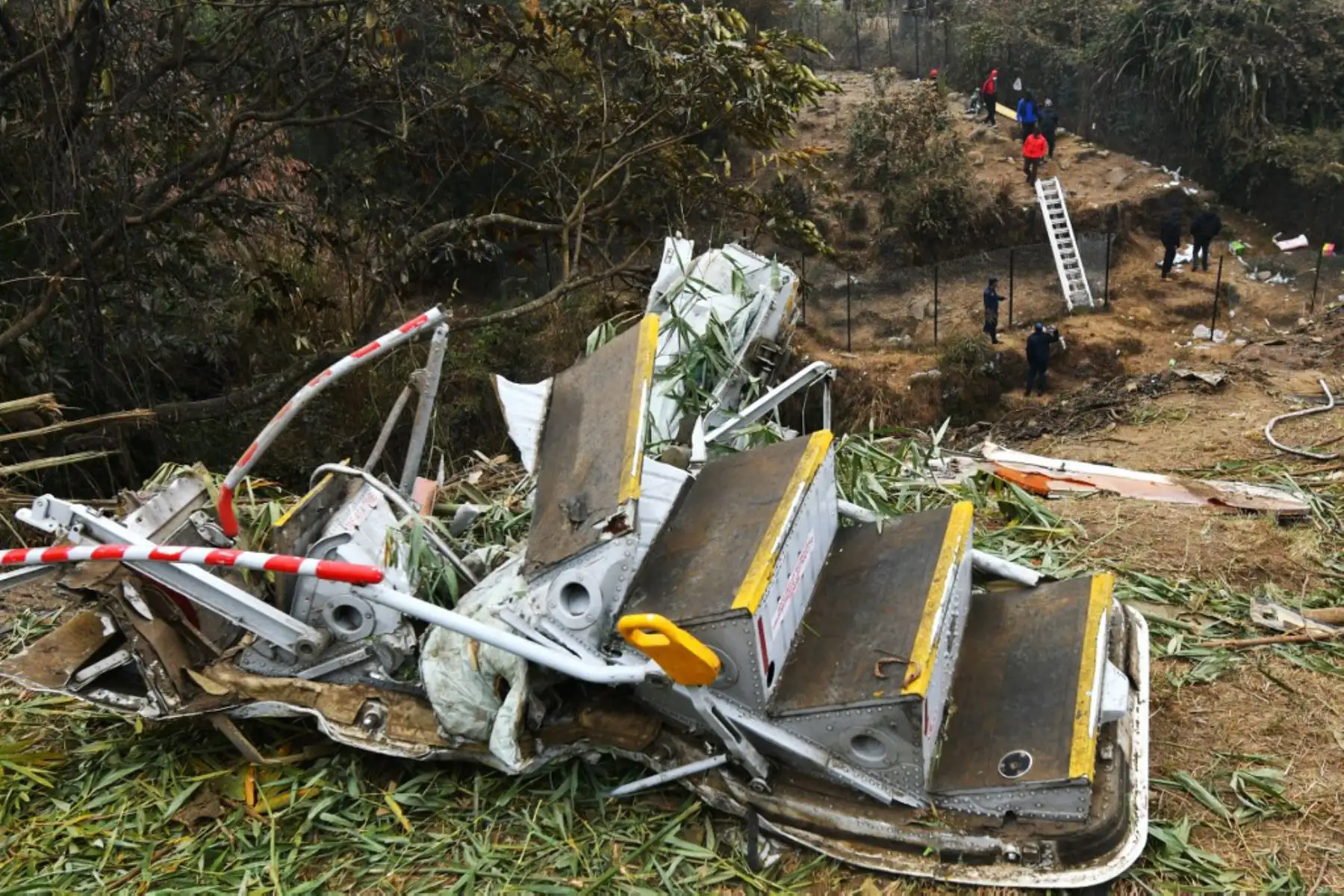 Rescatistas inspeccionan los restos en el lugar donde se estrelló un avión de Yeti Airlines en Pokhara. Foto: AFP