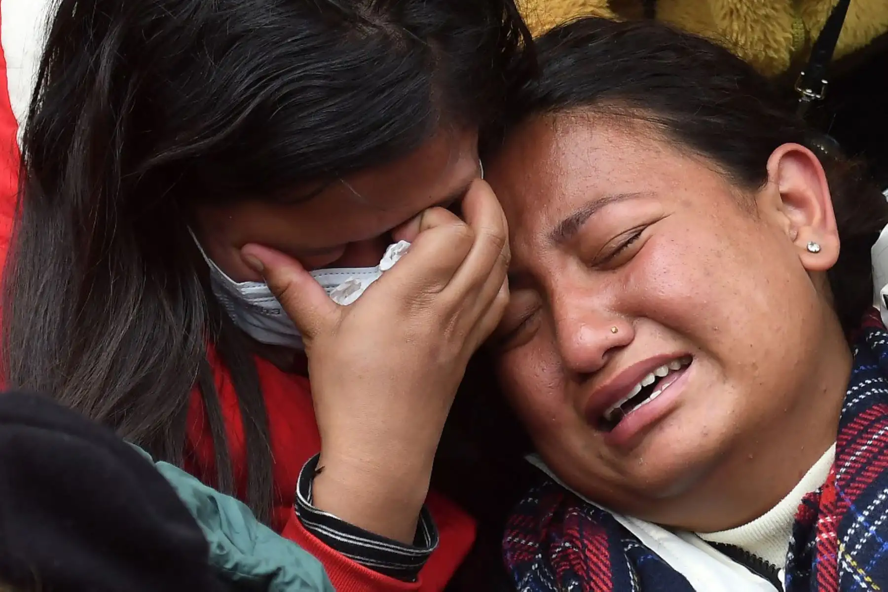Familiares y parientes de las víctimas que murieron en un accidente aéreo de Yeti Airlines, lloran afuera de un hospital en Pokhara. Foto: AFP