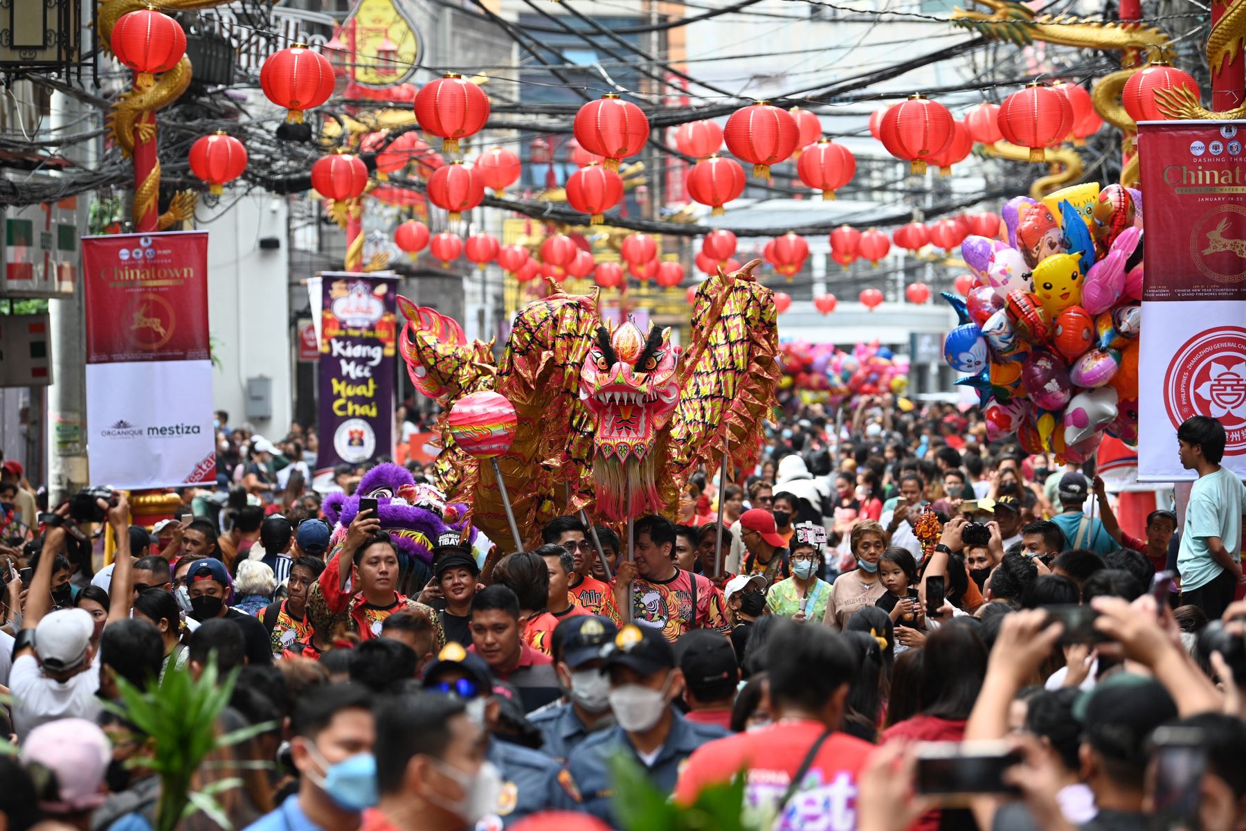 Los miembros de un grupo de danza del dragón chino caminan por una calle llena de juerguistas durante las celebraciones del año nuevo lunar en el barrio chino de Manila el 22 de enero de 2023.
Foto: AFP