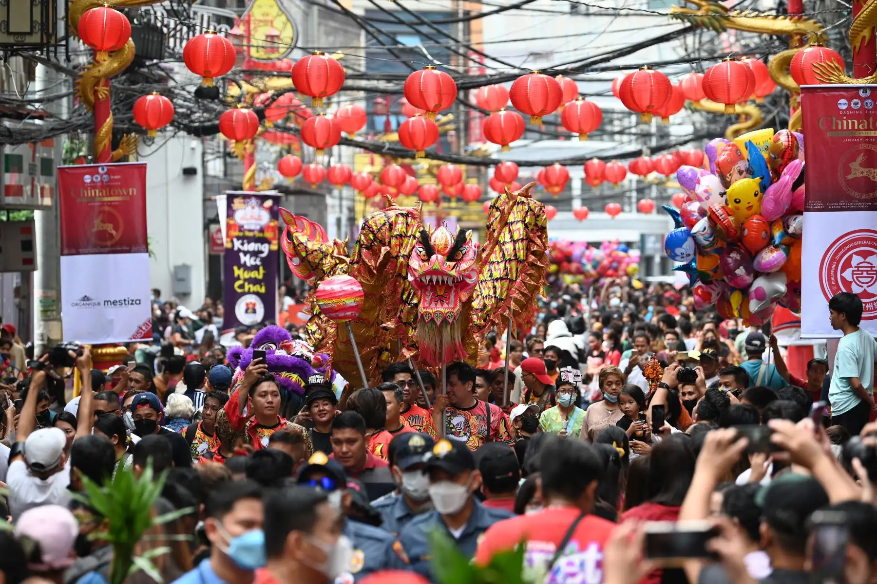 Los miembros de un grupo de danza del dragón chino caminan por una calle llena de juerguistas durante las celebraciones del año nuevo lunar en el barrio chino de Manila el 22 de enero de 2023.
Foto: AFP