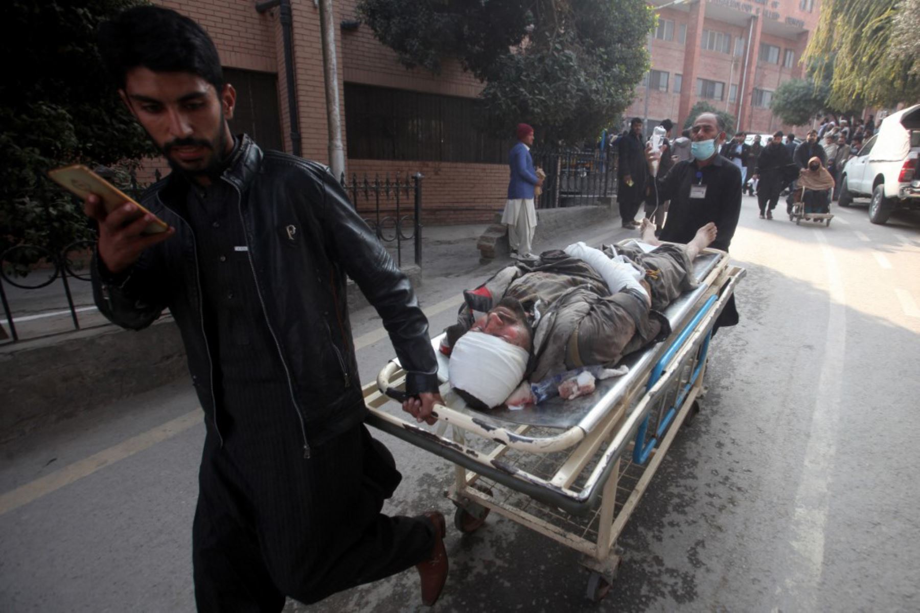La gente empuja una camilla que lleva a una víctima herida después de una explosión en una mezquita dentro de la sede de la policía. Foto: AFP