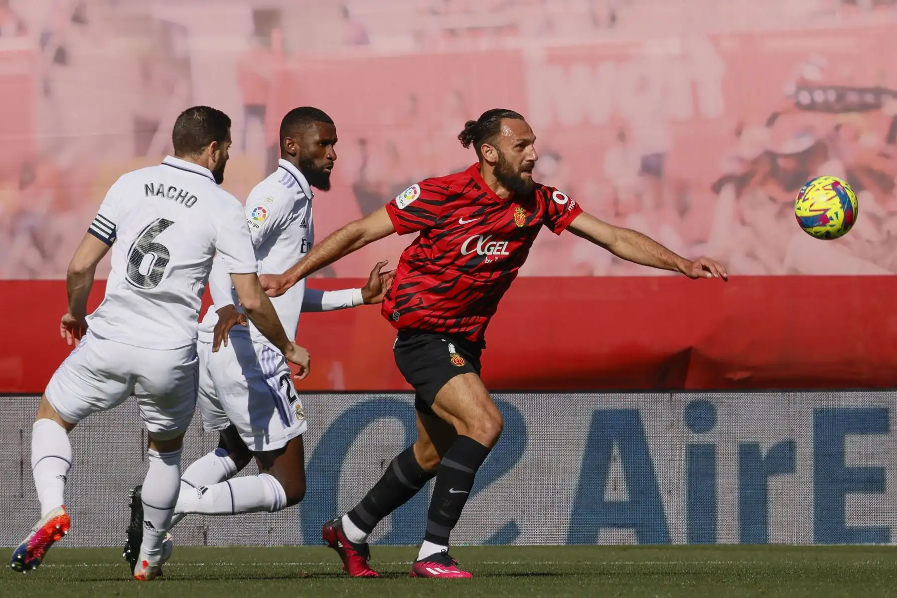 El delantero del Real Mallorca Vedat Muriqi se lleva la pelota ante los defensas del Real Madrid Nacho Fernández  y Antonio Rudger durante el Partido de La Liga que disputan el Mallorca y el Real Madrid en el estadio de Son Moix.
Foto: EFE