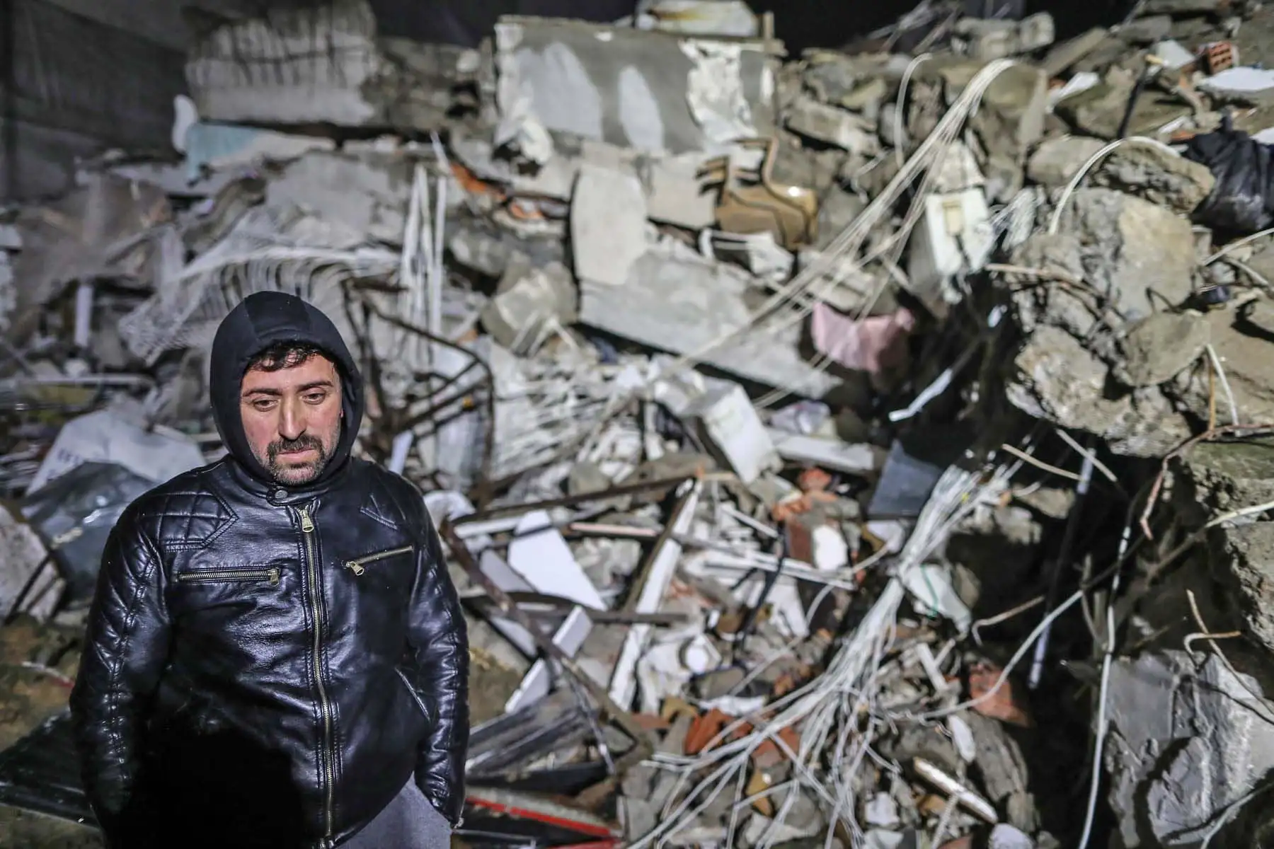 Un hombre espera mientras el personal de emergencia busca víctimas en el sitio de un edificio derrumbado después de un terremoto, hoy, en el distrito de Iskenderun de Hatay, Turquía. Más de 3.600 personas han muerto y otras 16.000 han resultado heridas en la serie de devastadores terremotos que ha sacudido el sureste de Turquía, cerca de la frontera con Siria. Foto: EFE