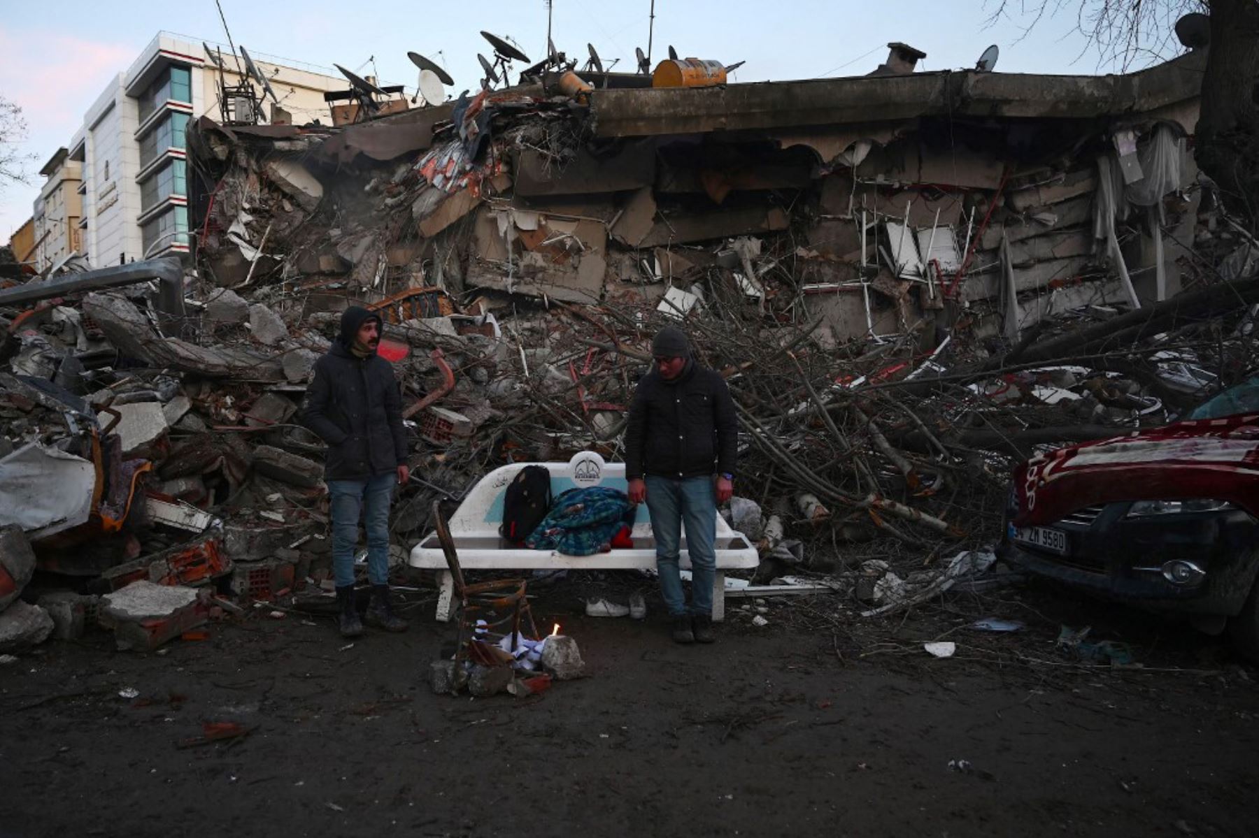La gente enciende una hoguera entre los escombros de los edificios derrumbados en Kahramanmaras. Foto: AFP