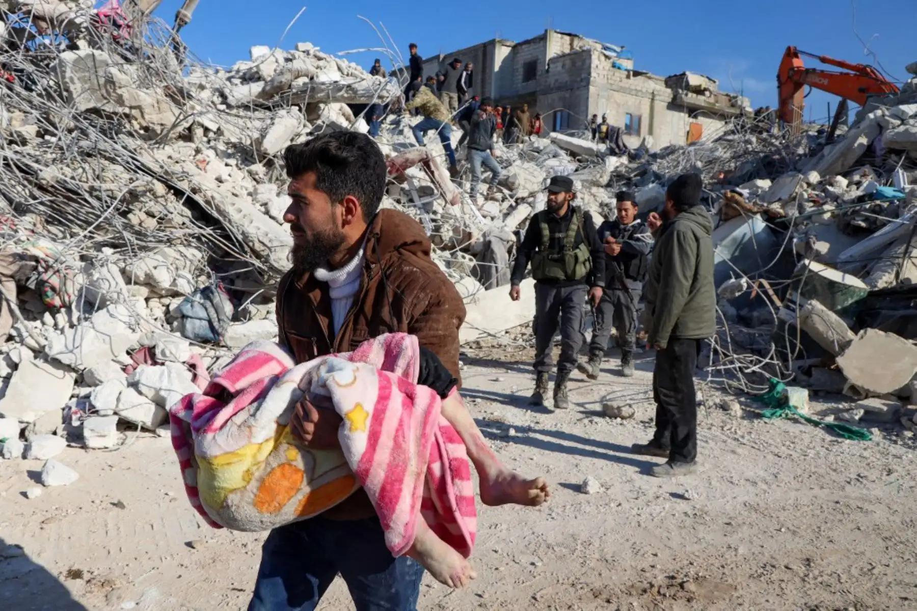 Un hombre lleva el cuerpo de un niño que sacó de los escombros en la ciudad de Harim, en la provincia noroccidental de Idlib en Siria. Foto: AFP