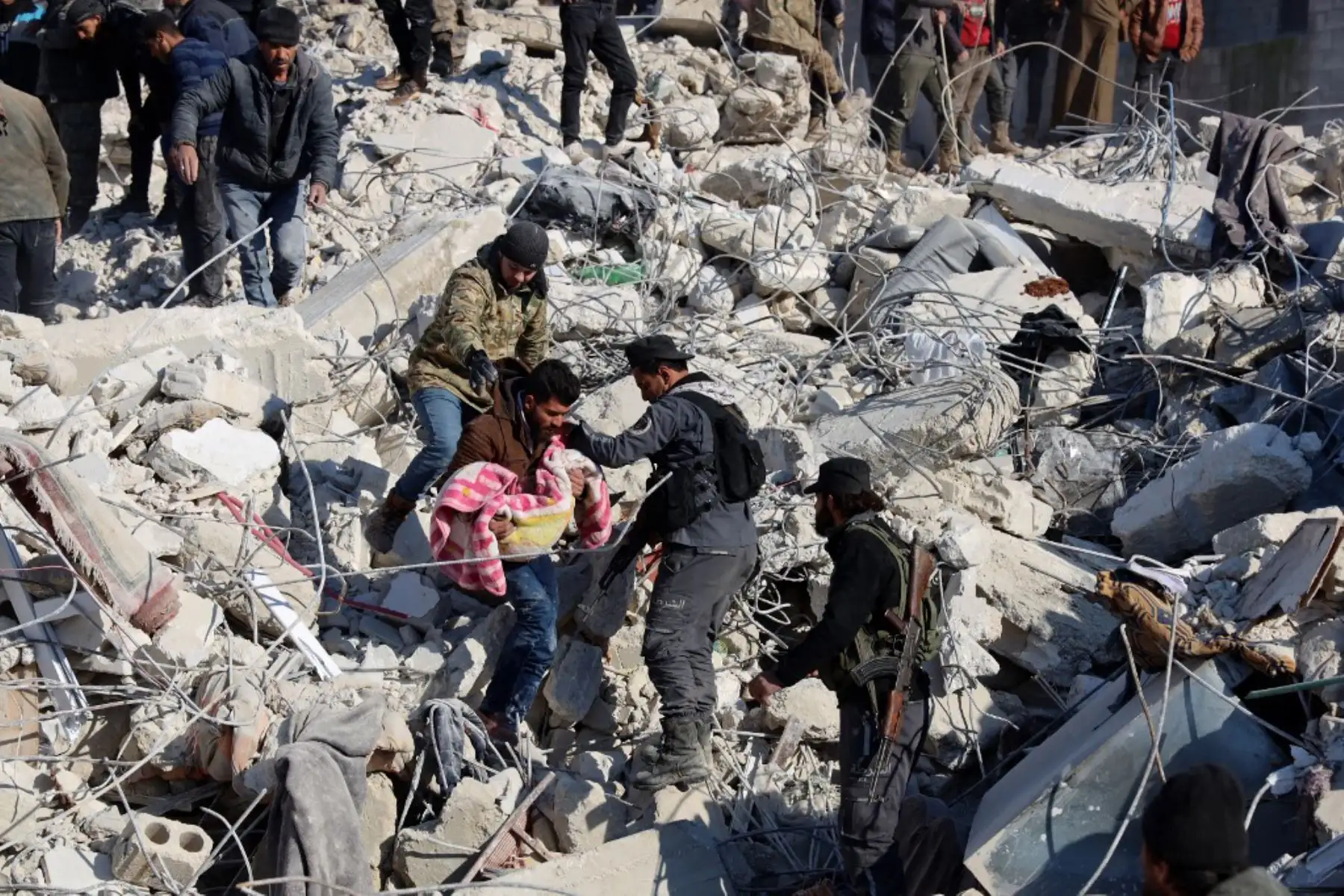 Un hombre lleva el cuerpo de un niño que sacó de los escombros en la ciudad de Harim, en la provincia noroccidental de Idlib en Siria. Foto: AFP
