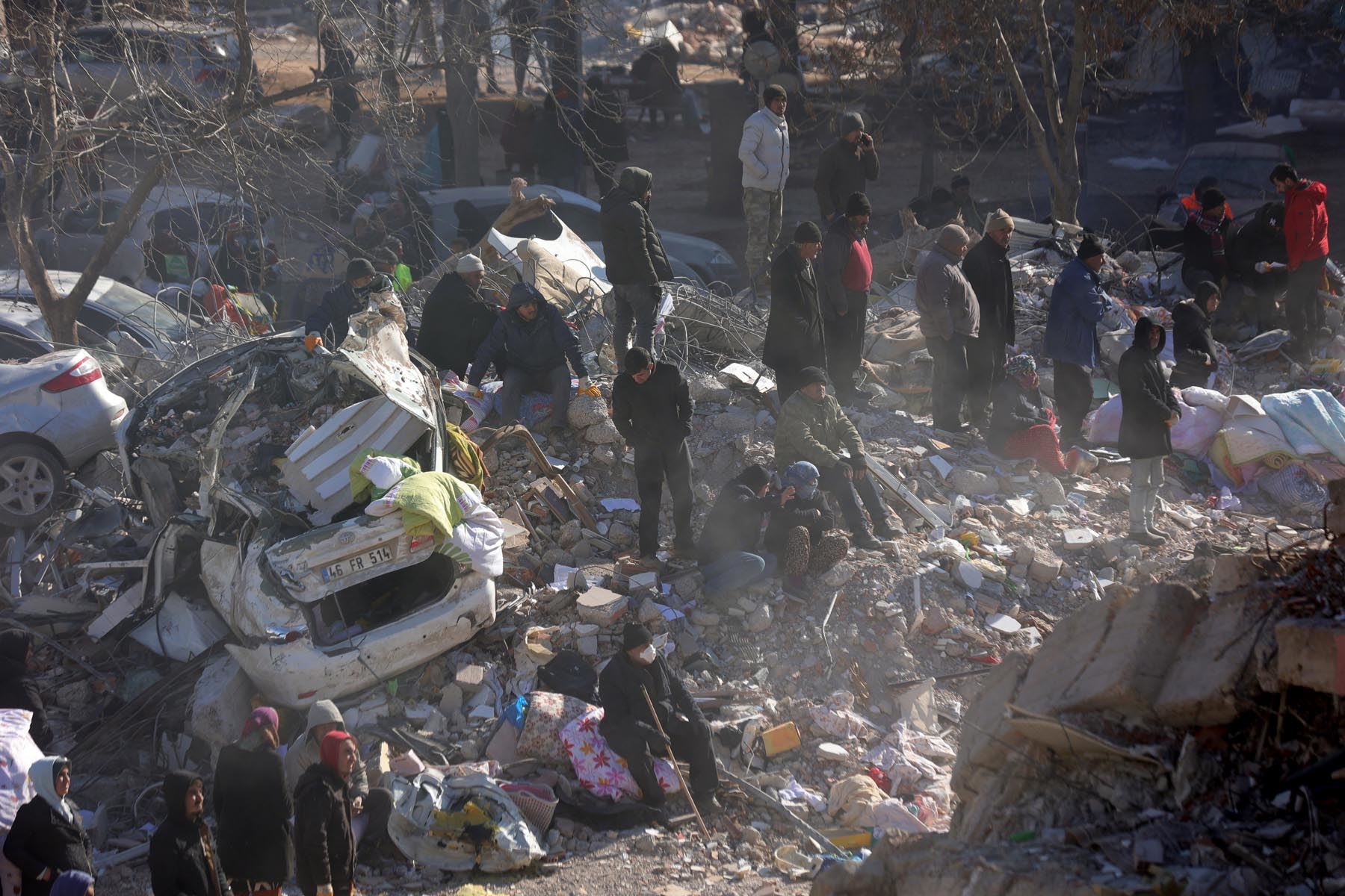 Gente ante los escombros de un edificio derrumbado en la ciudad de Kahramanmaras, en el sureste de Turquía. Foto: AFP