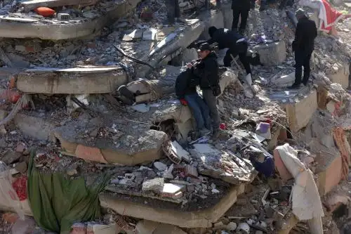 Gente ante los escombros de un edificio derrumbado en la ciudad de Kahramanmaras, sureste de Turquía. Foto: AFP