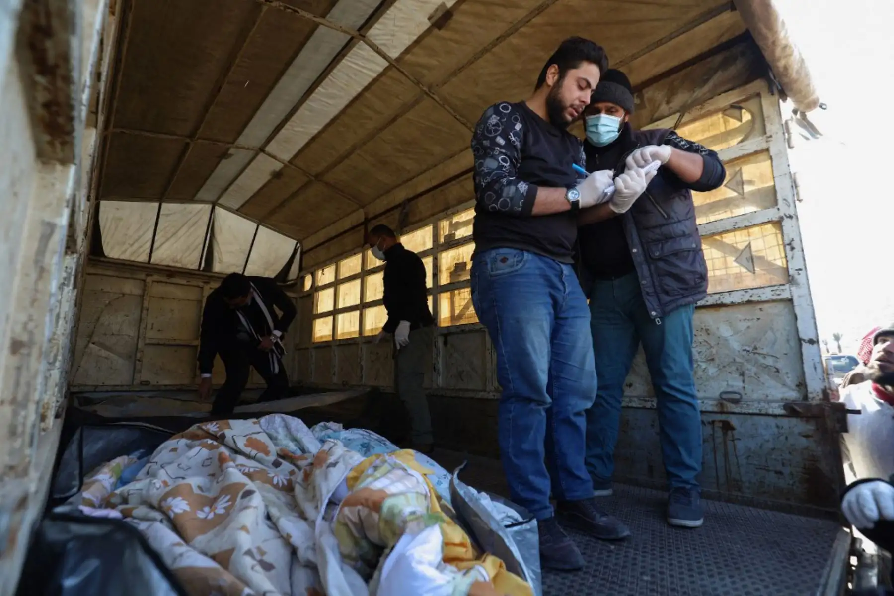 Los trabajadores gritan los nombres de las víctimas, muertas en un terremoto en Turquía, a su llegada a Siria. Foto: AFP
