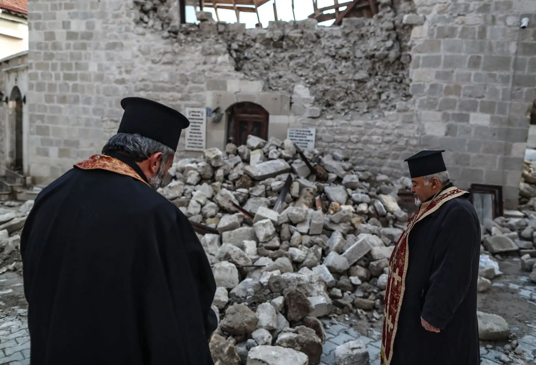 Los sacerdotes se paran en la Iglesia Ortodoxa Griega Virgen María colapsada después de un terremoto en Altinozu, distrito de Hatay, Turquía.
Foto: EFE