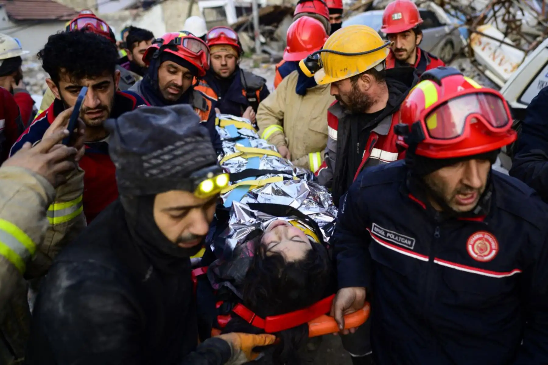 Rescatistas evacuan a una niña siria de los escombros de un edificio destruido en Hatay. Foto: AFP