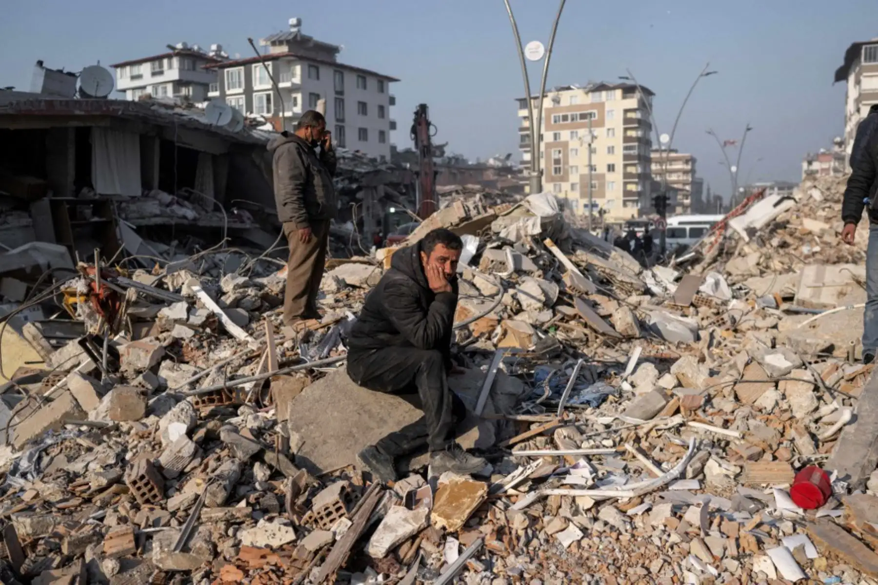 Un hombre se sienta sobre los escombros de un edificio derrumbado durante las operaciones de rescate en Hatay. Foto: AFP