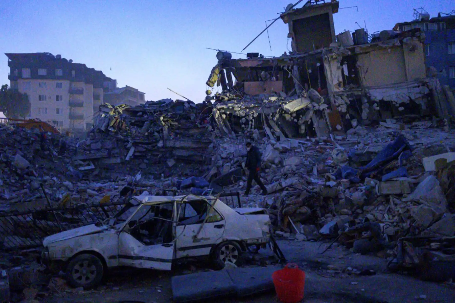 Un hombre camina entre los escombros de los edificios derrumbados en Hatay, cuando los equipos de rescate comenzaron a reducir la búsqueda de sobrevivientes, una semana después de que un terremoto devastara partes de Turquía y Siria. Foto: AFP