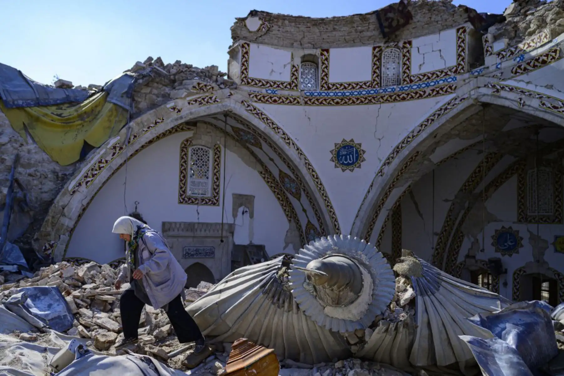 Una mujer camina entre los escombros de los edificios derrumbados en Hatay, cuando los equipos de rescate comenzaron a reducir la búsqueda de sobrevivientes, una semana después de que un terremoto devastara partes de Turquía y Siria. Foto: AFP