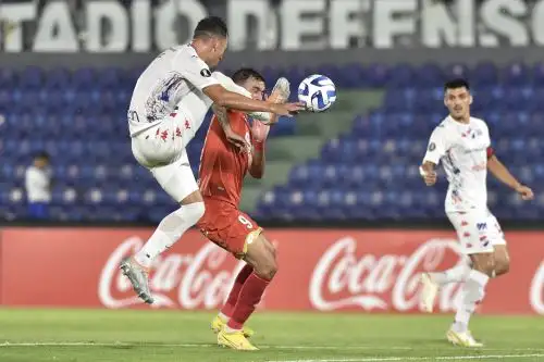 El defensor de Nacional, Francisco Báez (L), lucha por el balón con el delantero chileno de Sport Huancayo, Carlos Escobar, durante el partido de vuelta de la etapa uno de la Copa Libertadores entre Nacional y Sport Huancayo, en el estadio Defensores del Chaco en Asunción, el 14 de febrero de 2023. Foto: AFP