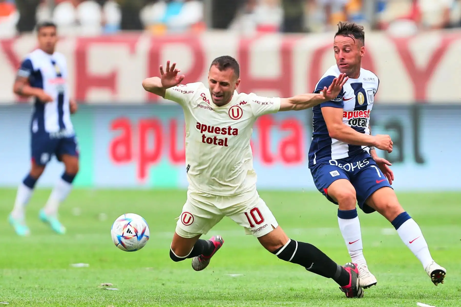 El jugador Horacio Calcatrerra de Universitario de Deportes disputa el balón con el jugador Pablo Lavandeira de  Alianza Lima en el clásico del fútbol peruano por la quinta jornada de la Liga 1 en el estadio Monumental de Ate.
Foto: ANDINA/Ricardo Cuba
