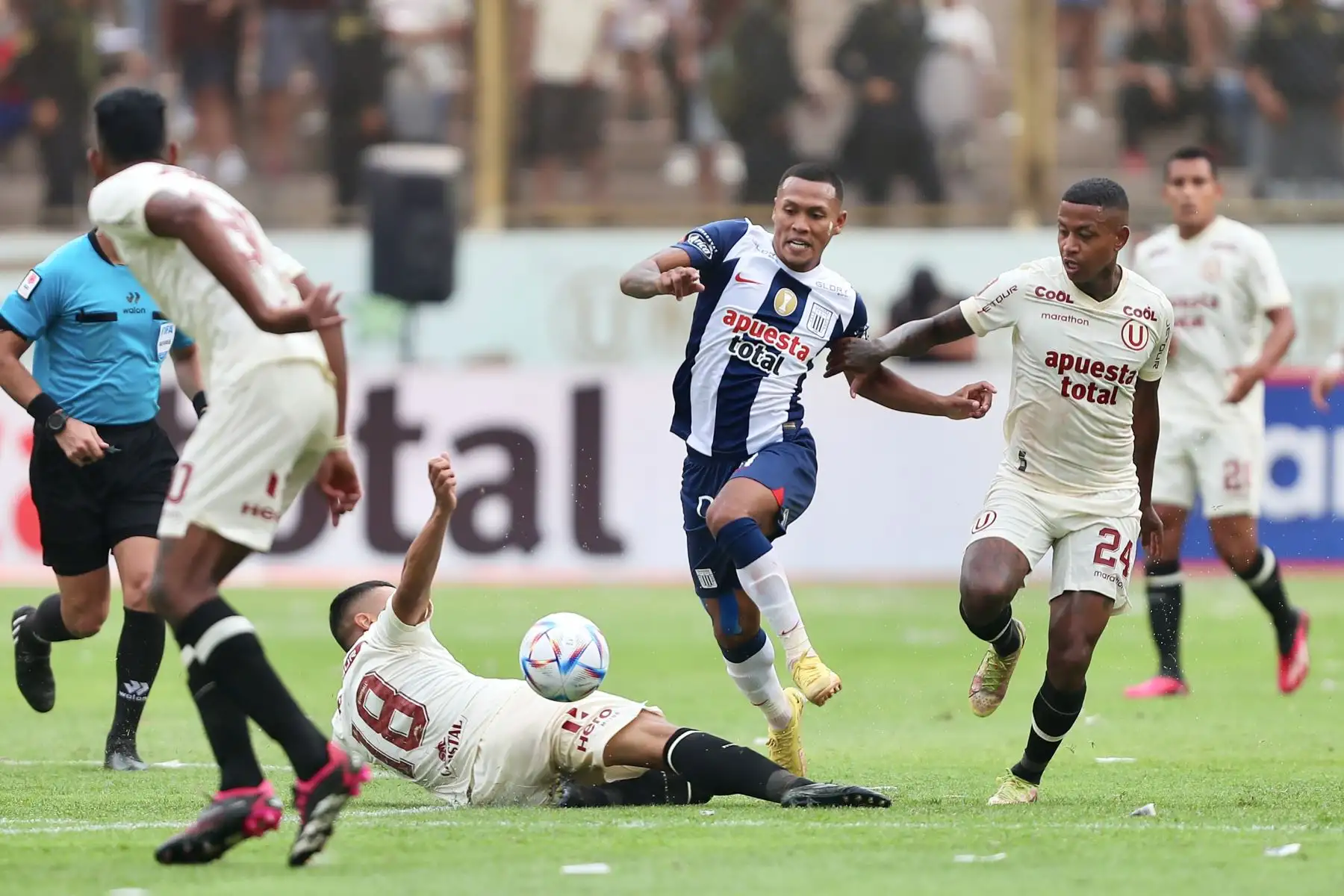 El jugador Bryan Reyna de  Alianza Lima  disputa el balón con el jugador  Andy Polo de  Universitario de Deportes  en el clásico del fútbol peruano por la quinta jornada de la Liga 1 en el estadio Monumental de Ate.
Foto: ANDINA/Ricardo Cuba