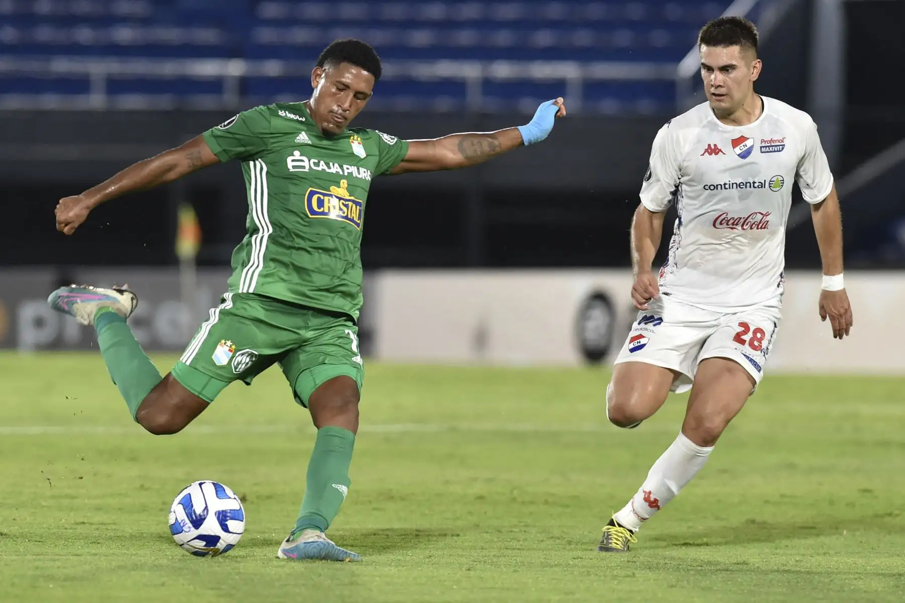 El mediocampista de Sporting Cristal, Jesús Castillo, golpea el balón mientras el delantero de Nacional, Cristhian Ocampos, observa durante el partido de ida de la segunda ronda de la Copa Libertadores entre Nacional de Paraguay y Sporting Cristal de Perú, en el estadio Defensores del Chaco en Asunción.
Foto:AFP
