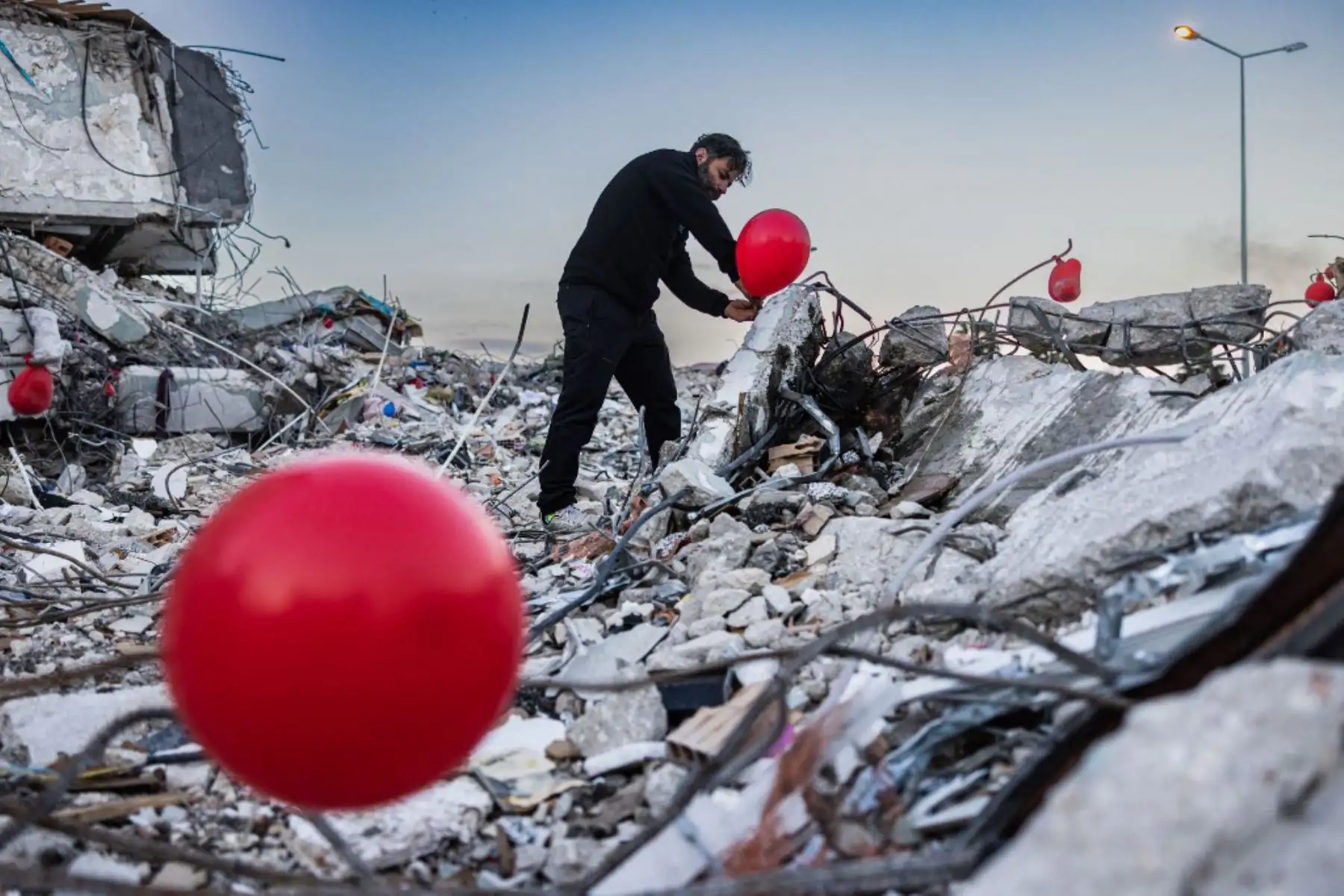 Globos rojos revolotean, colgando de las ruinas. Son "los últimos juguetes" de los niños fallecidos durante el terremoto que asoló esta ciudad del sur de Turquía, explica Ogun Sever Okur, autor de este regalo póstumo. Foto: AFP