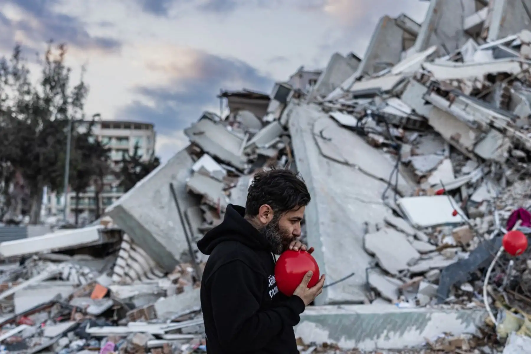 Globos rojos revolotean, colgando de las ruinas. Son "los últimos juguetes" de los niños fallecidos durante el terremoto que asoló esta ciudad del sur de Turquía, explica Ogun Sever Okur, autor de este regalo póstumo. Foto: AFP