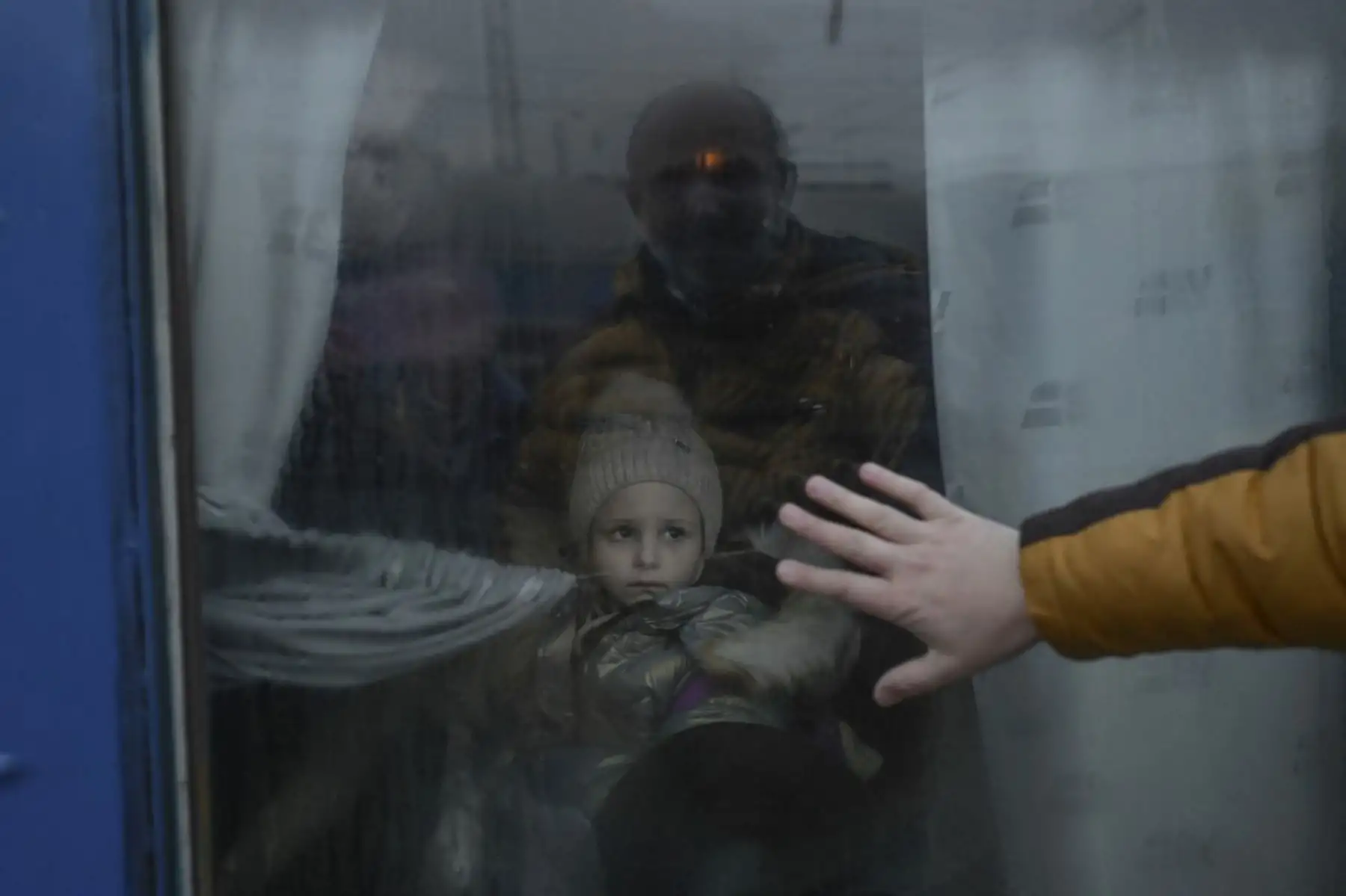 Un padre pone su mano en la ventana mientras se despide de su hija frente a un tren de evacuación en la estación central de trenes de Odessa el 7 de marzo de 2022. Foto: AFP
